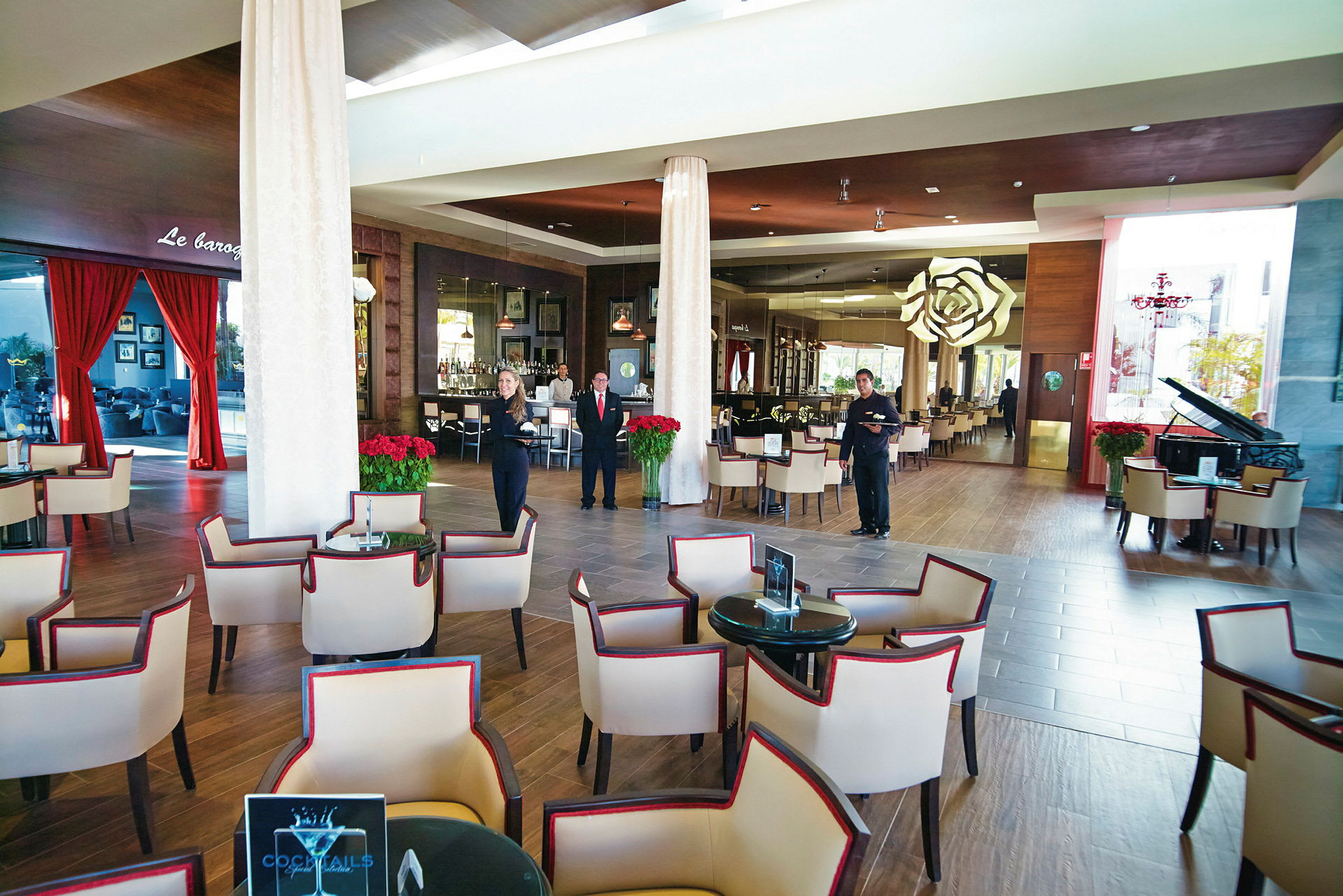 Et siddeområde med polstrede stole og borde i en stilfuld hotelbar med moderne indretning. (AI-genereret tekst)
