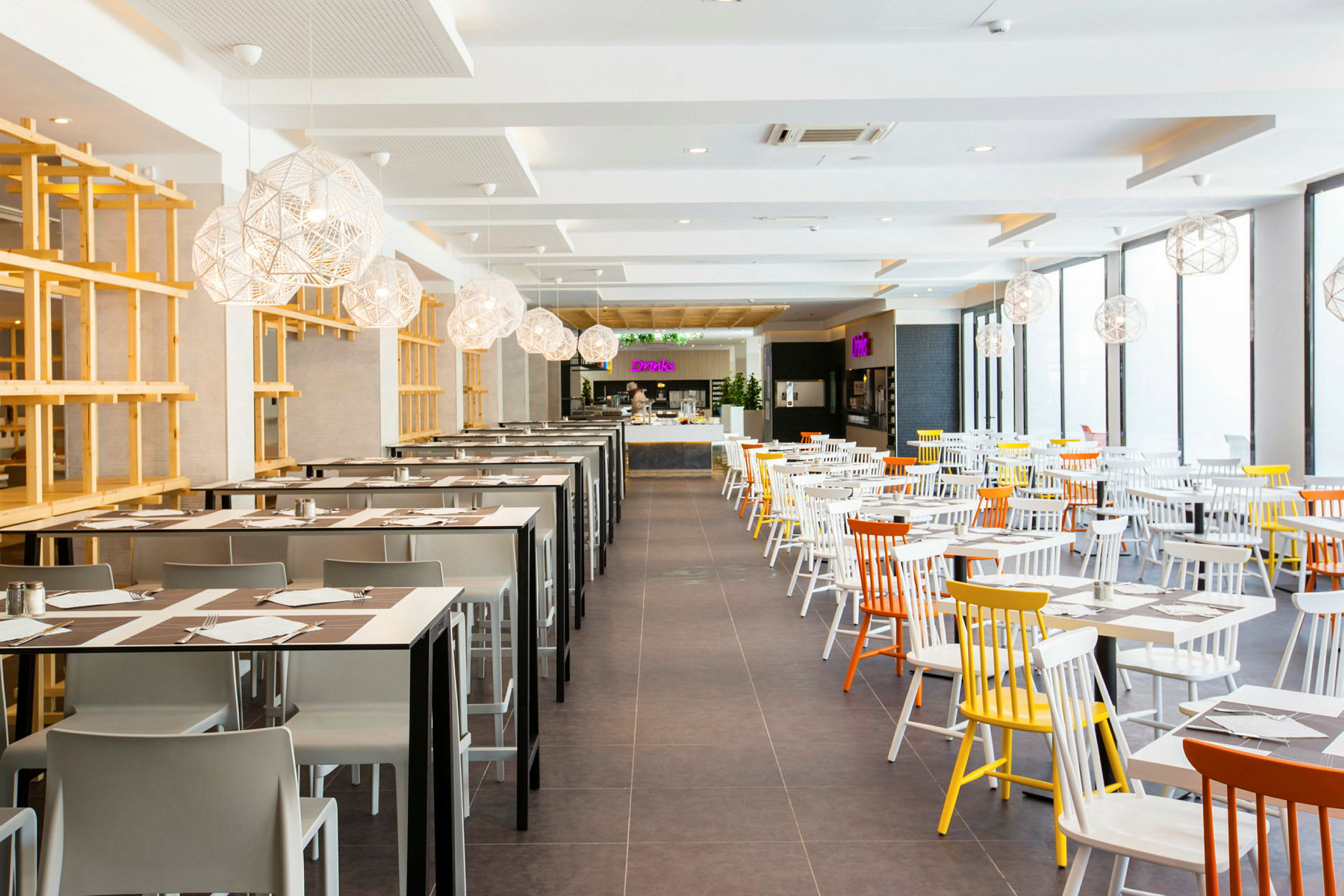 Lyse møblerede restaurant med farverige detaljer. (AI-genereret tekst)