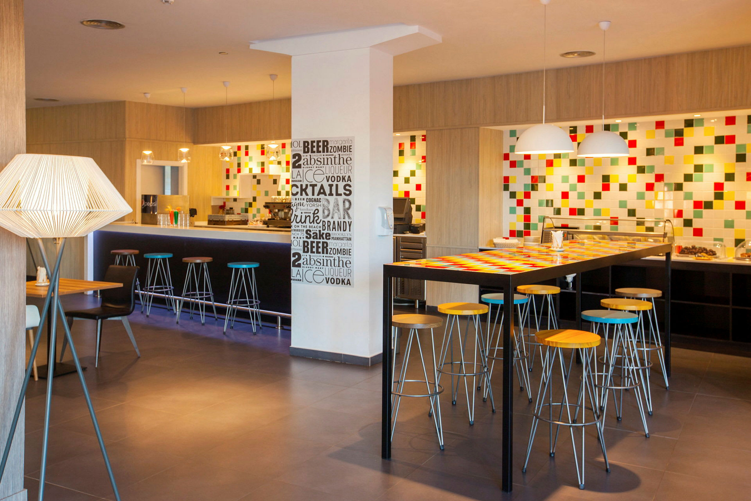 En moderne bar med høje stole og farverigt vægdekoration. (AI-genereret tekst)