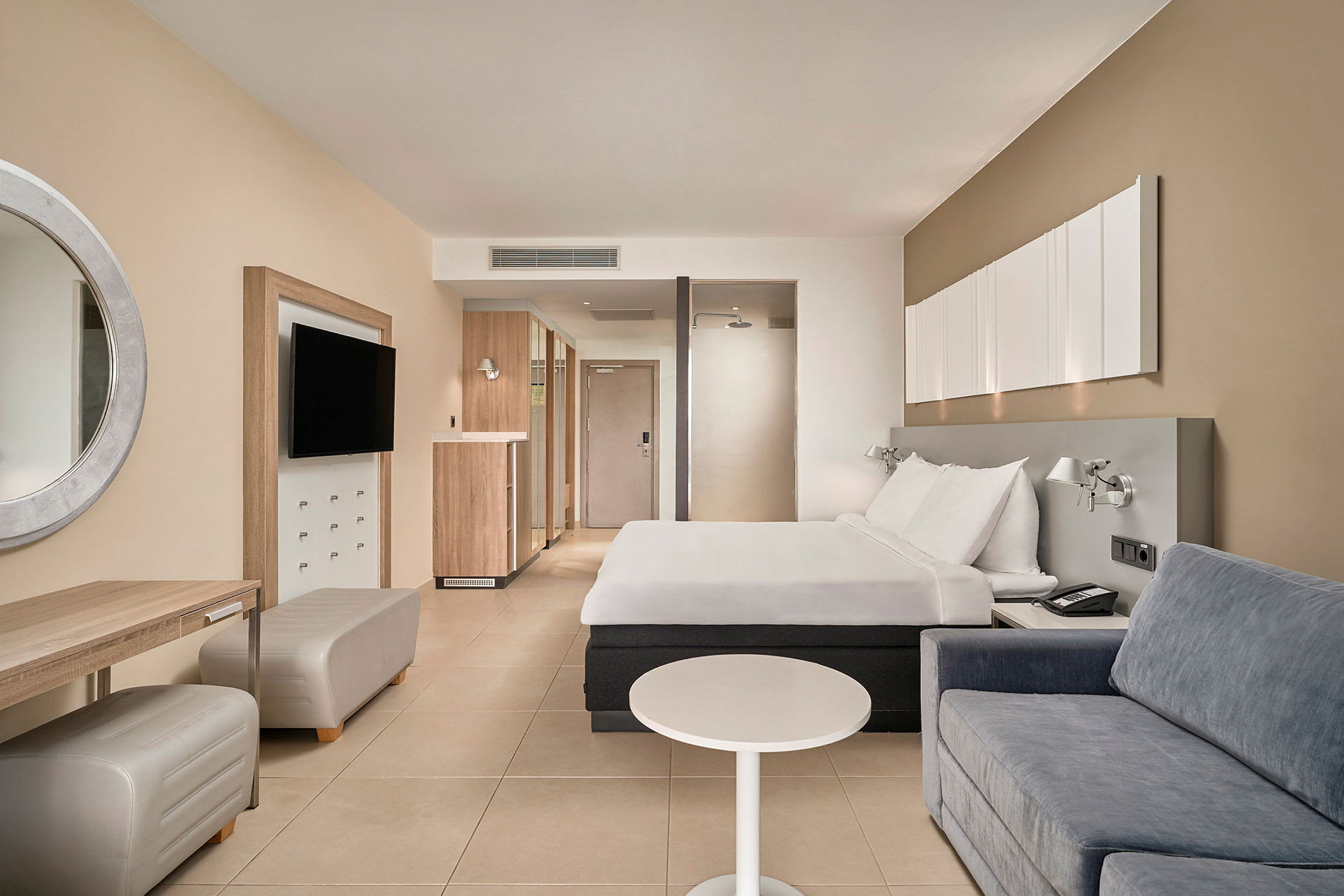 Hotelværelse med en dobbeltseng, sofa og skrivebord. (AI-genereret tekst)