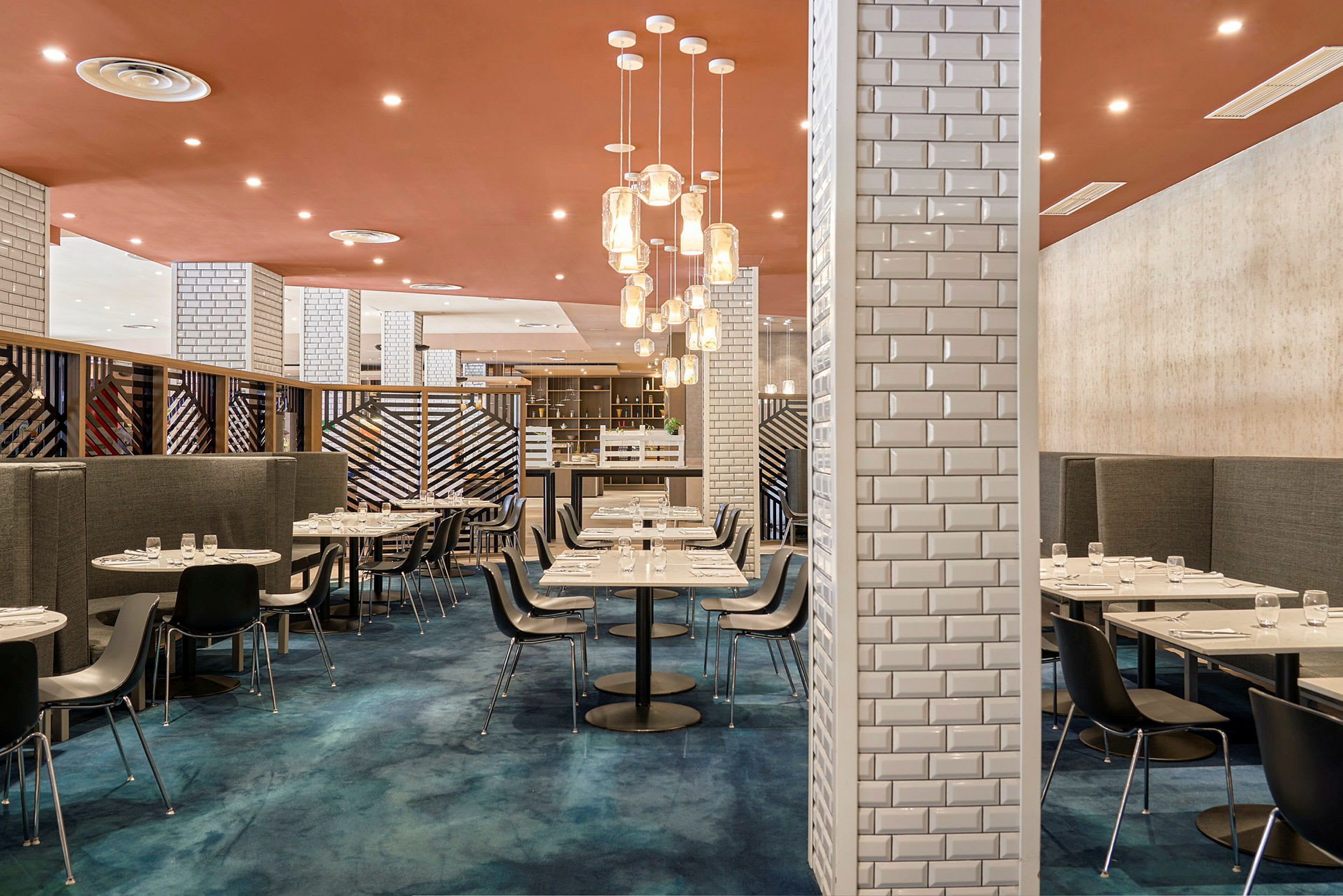 En moderne restaurant med stilfuld indretning, blåt gulv og elegante borde. (AI-genereret tekst)