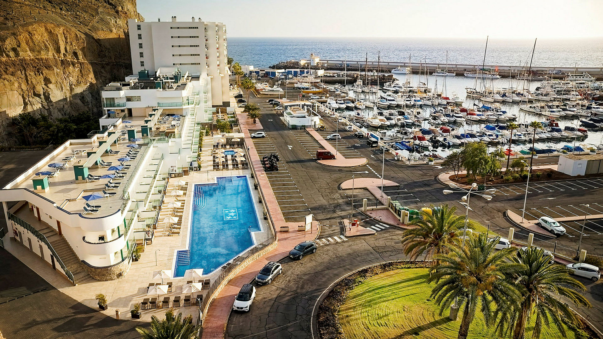 Hotellets poolområde og marina med både ved kysten. (AI-genereret tekst)