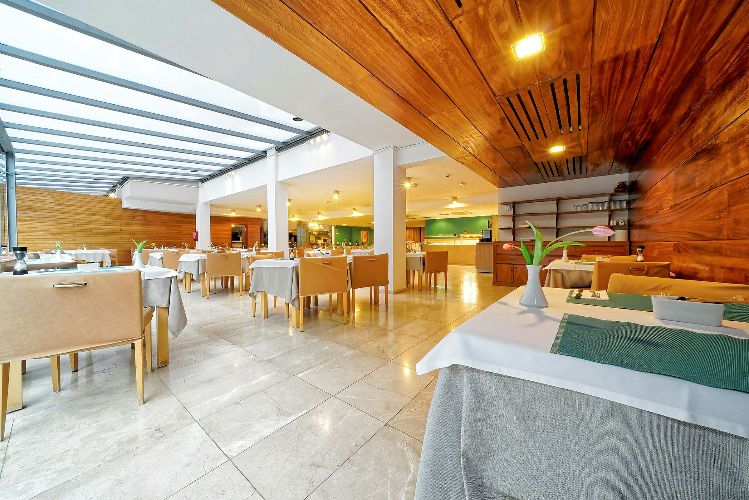 En moderne restaurant med træpaneler, dækkede borde og hvide stole. (AI-genereret tekst)