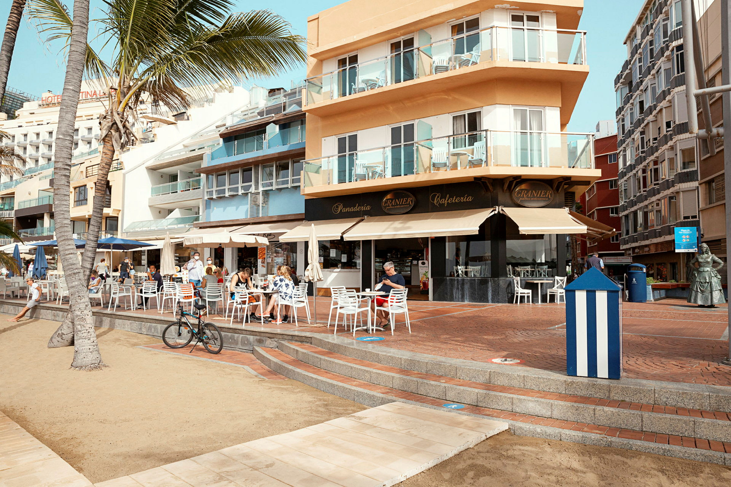 Café og bygning ved en strandpromenade. (AI-genereret tekst)