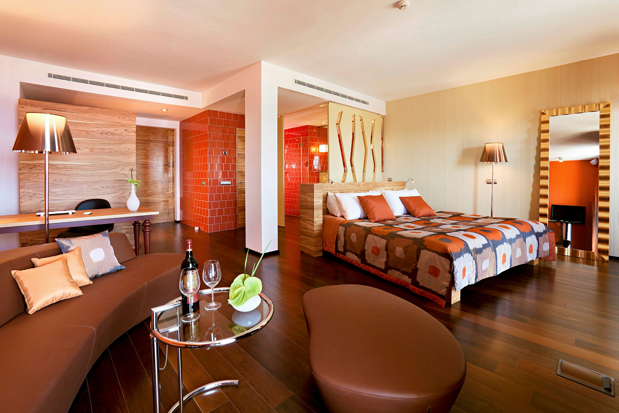 Et hotelværelse med moderne indretning, orange detaljer og en dobbeltseng. (AI-genereret tekst)