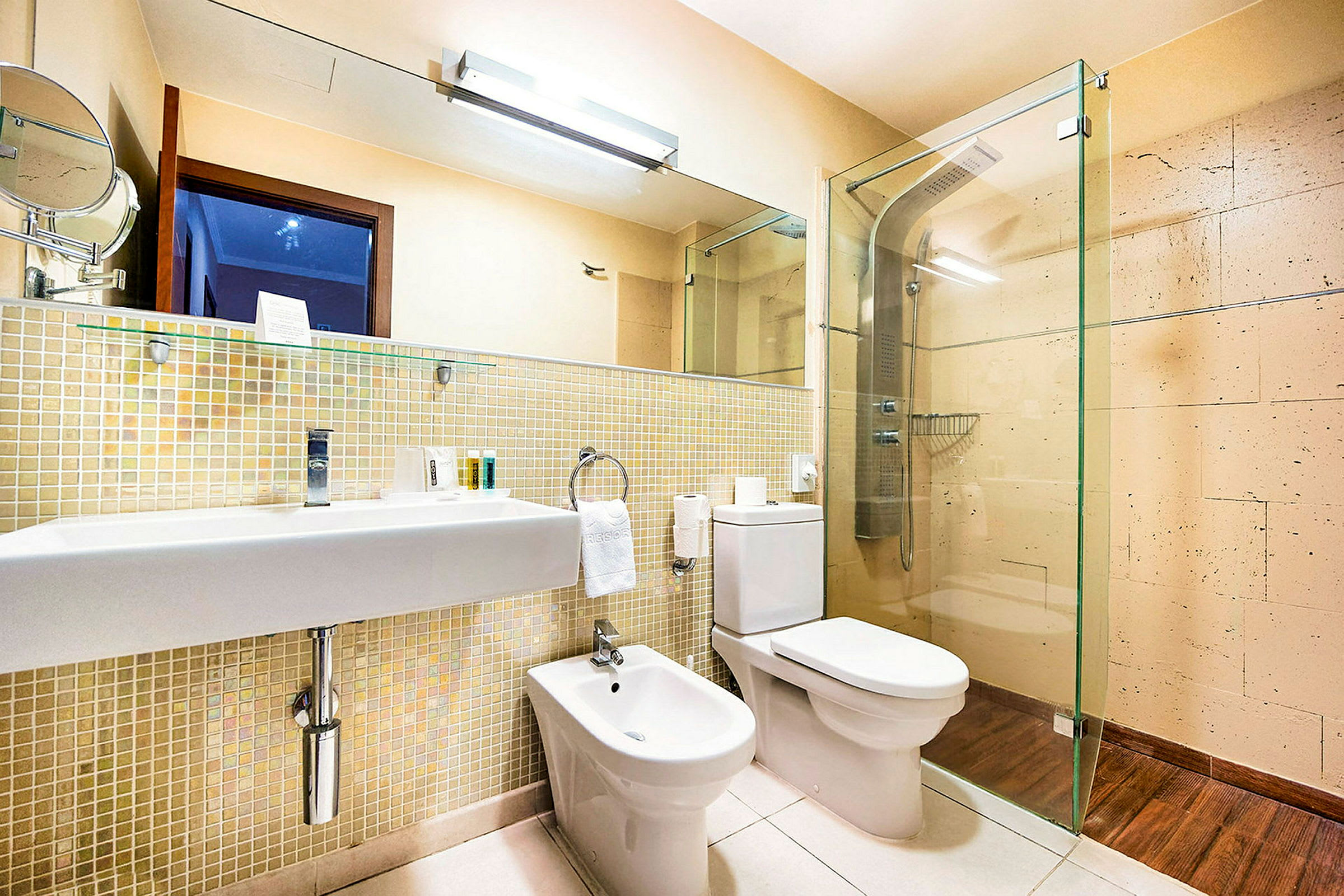 Et moderne badeværelse med håndvask, toilet, bidet og brusebad. (AI-genereret tekst)