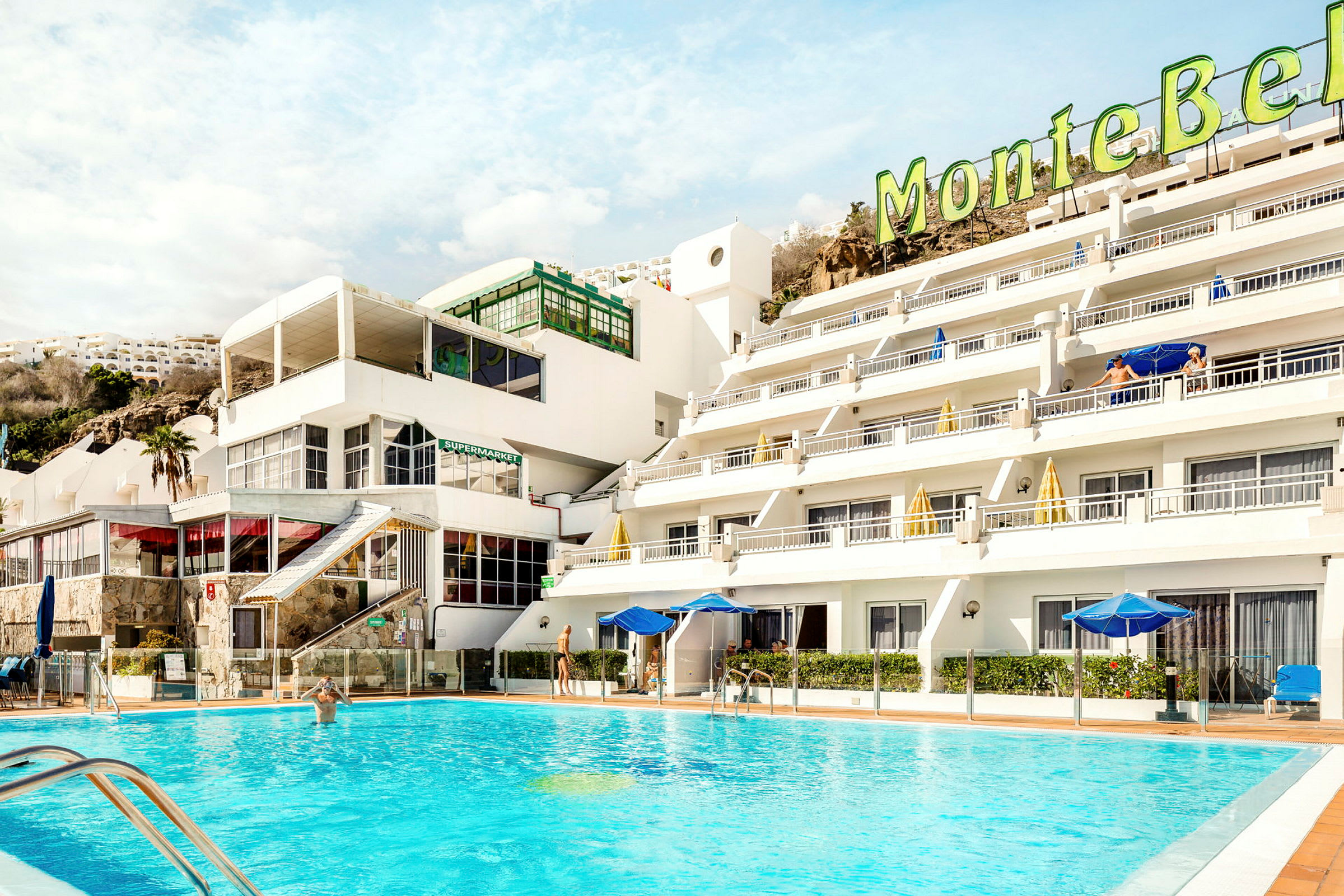 Hotel med poolområde og lyse bygninger. (AI-genereret tekst)