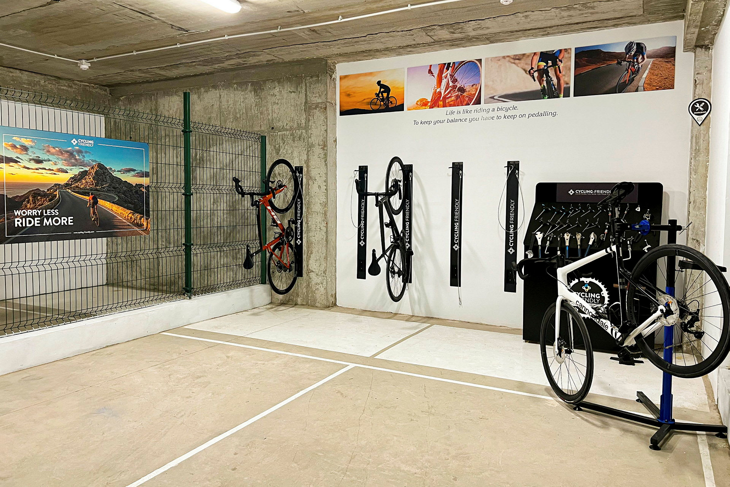 Et cykelopbevaringsområde med flere cykler hængt op på væggen og skilte, der fremhæver cykling. (AI-genereret tekst)