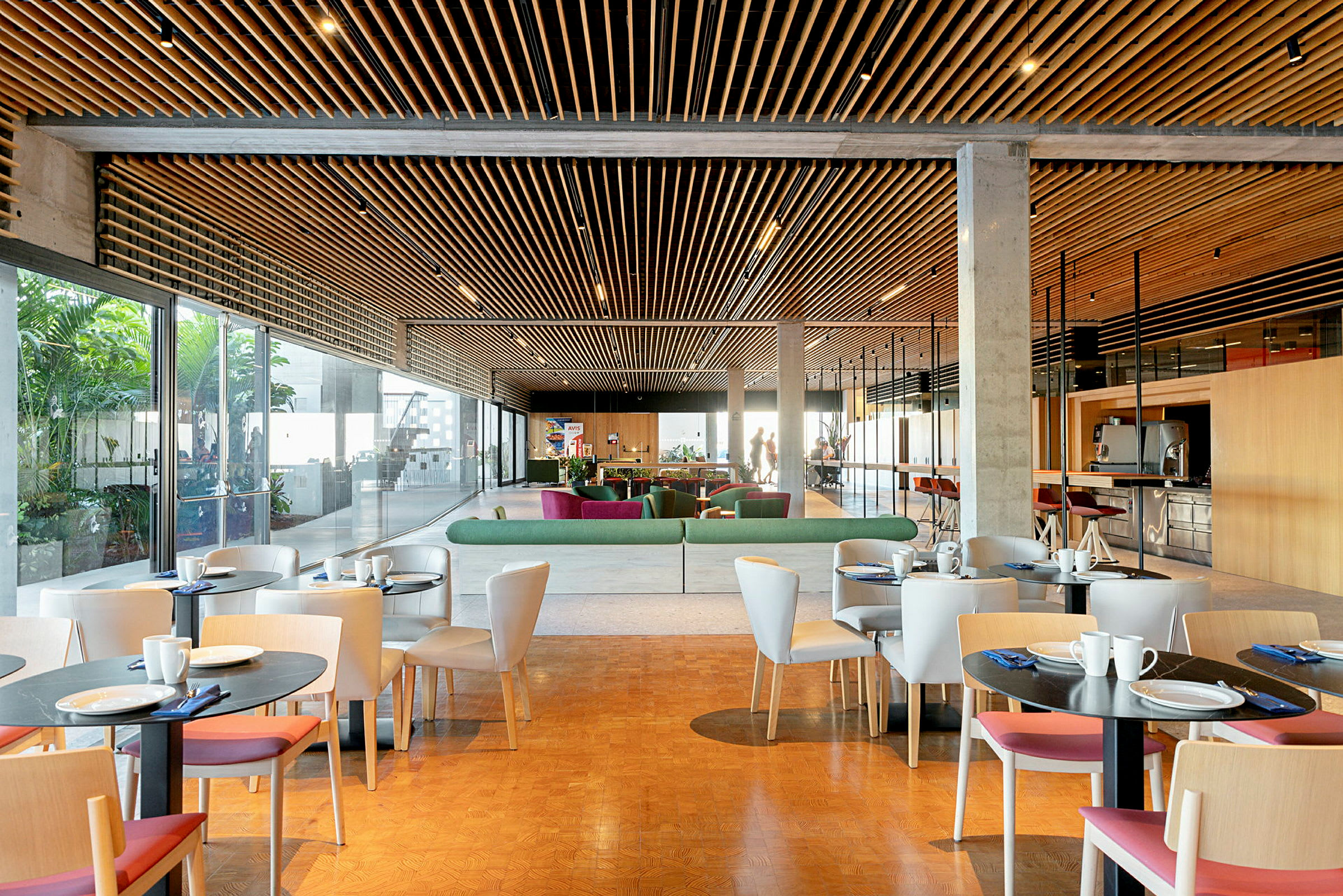 En moderne lounge med borde og stole, sofaer og et glastak. (AI-genereret tekst)