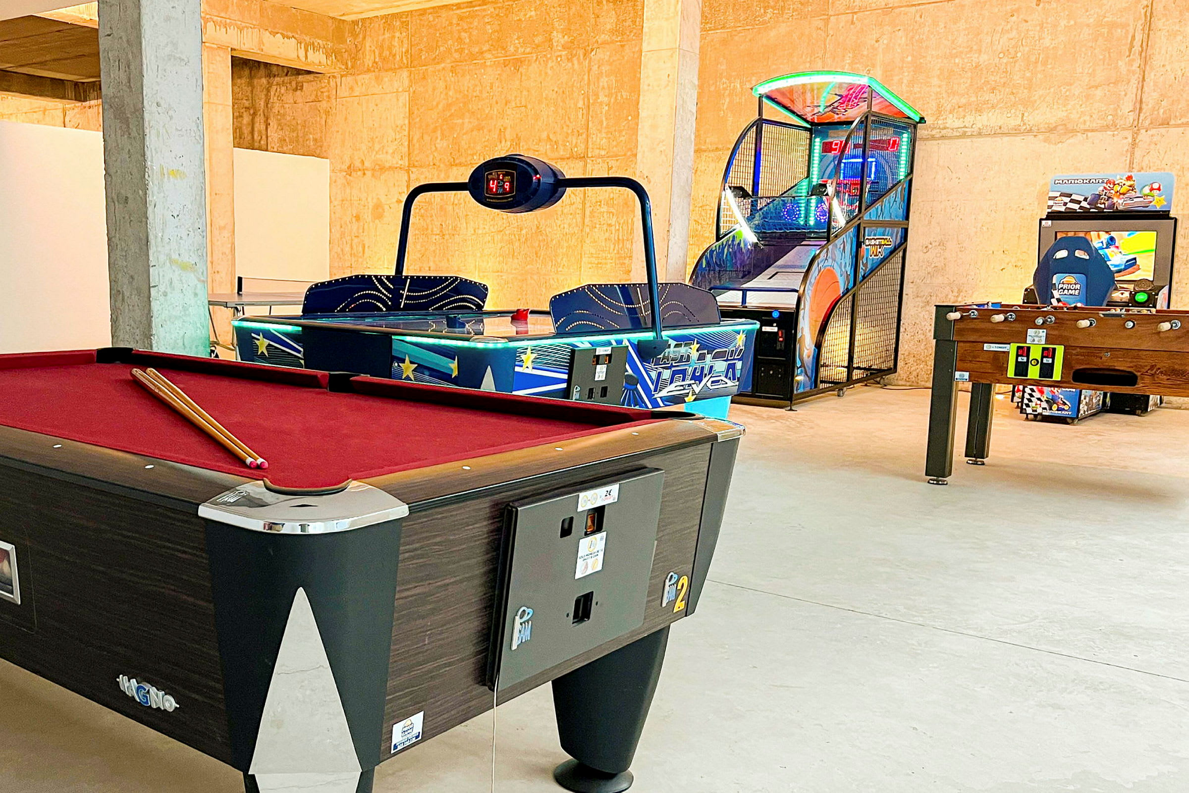 Et legerum med billardbord, airhockey, basketballskydespil og bordfodbold. (AI-genereret tekst)
