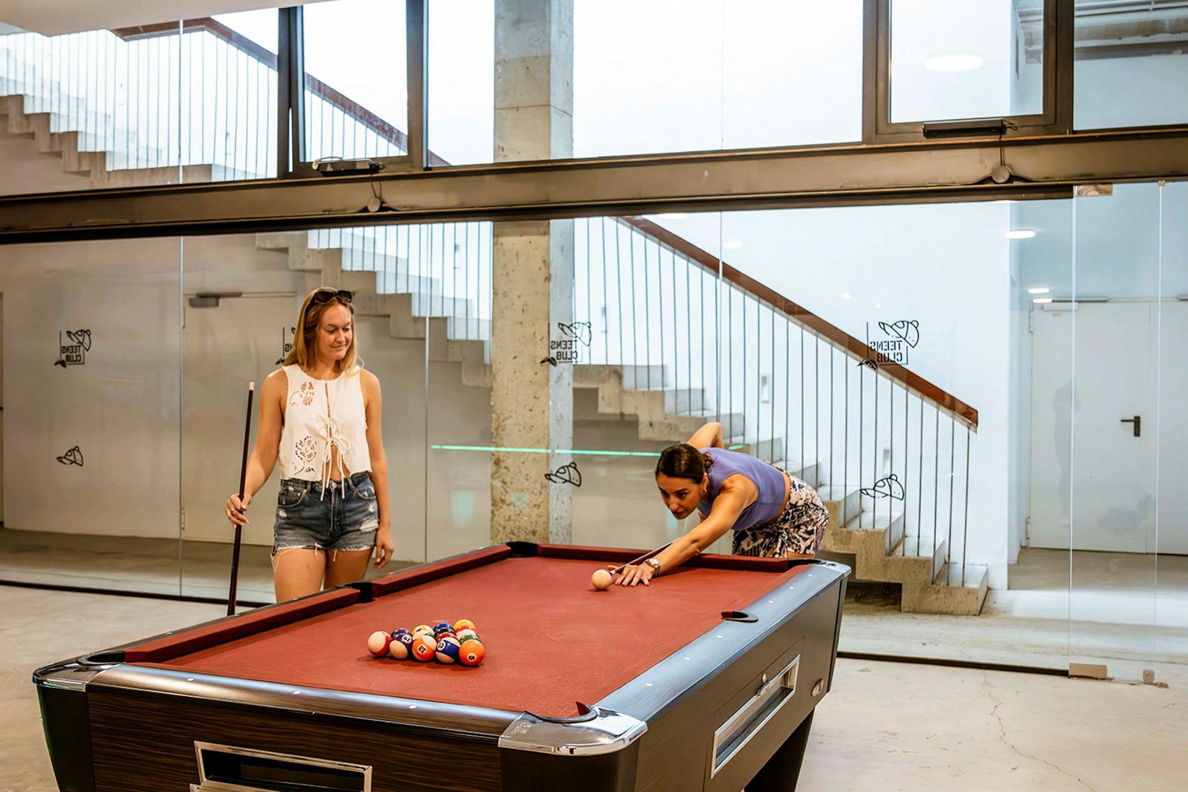 Personer spiller på et billiardbord i en moderne omgivelser. (AI-genereret tekst)