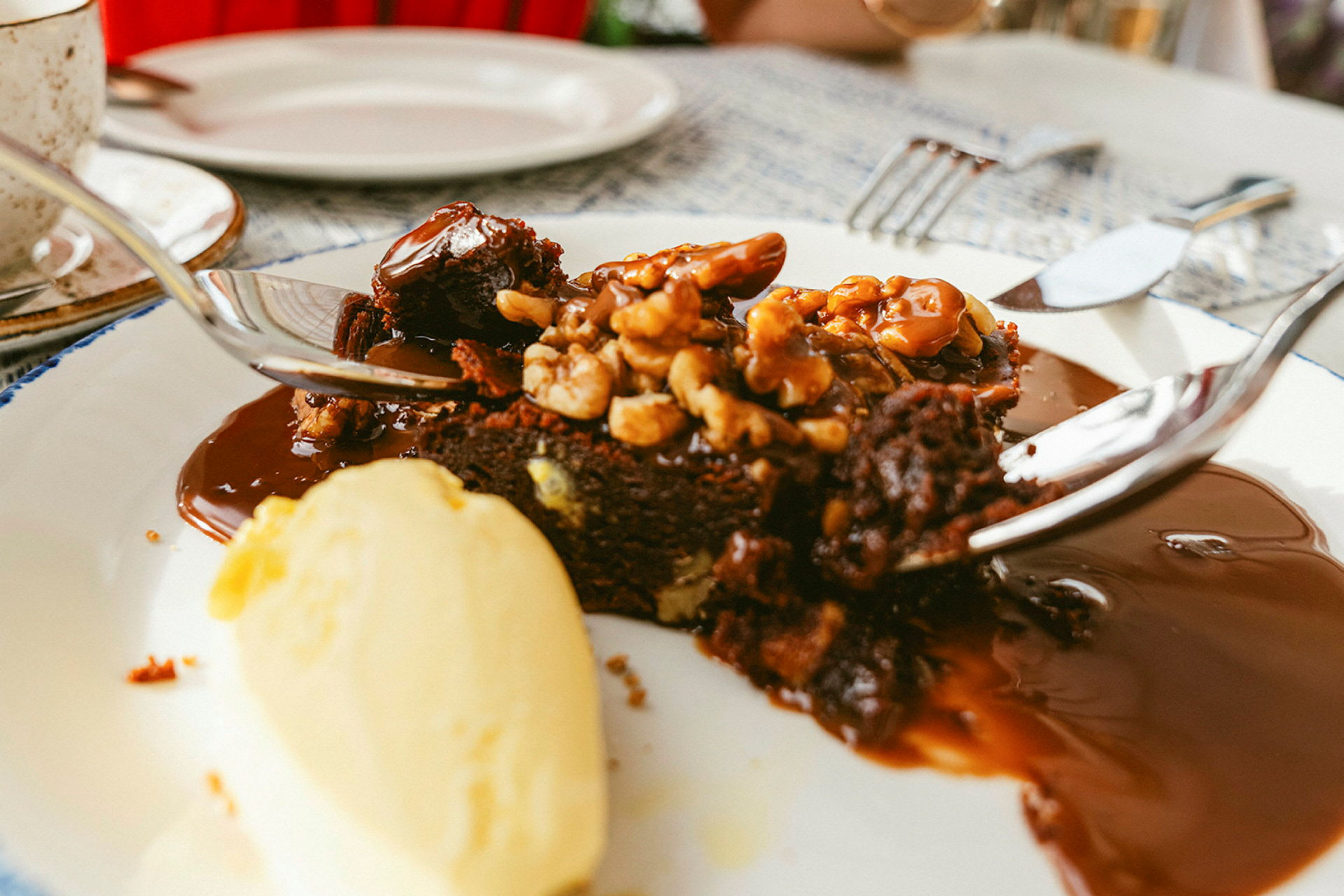 Chokoladekage serveret med nødder, sauce og vaniljeis. (AI-genereret tekst)