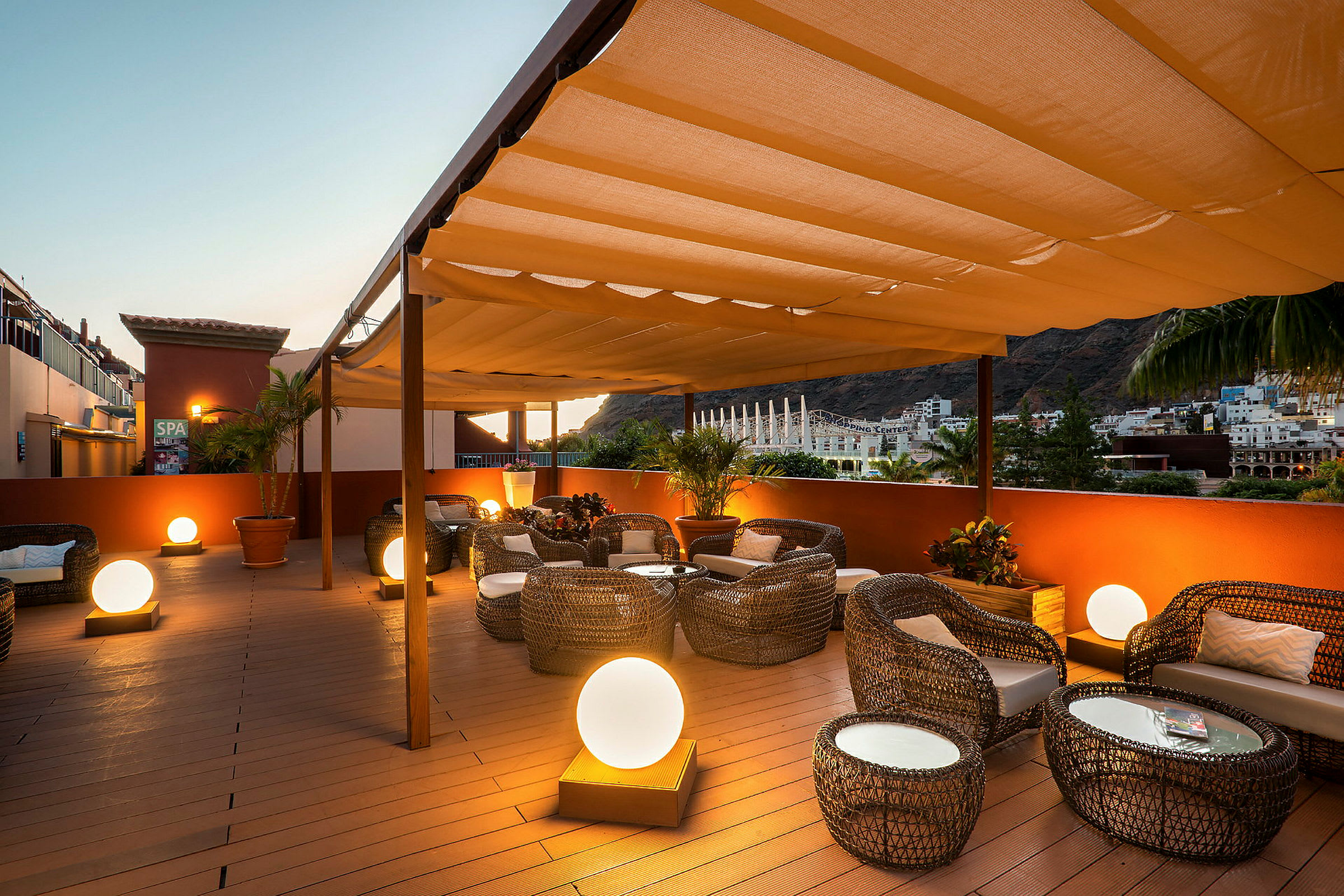 Udendørs terrasse med siddepladser, planter og dekorative lysbolde. (AI-genereret tekst)
