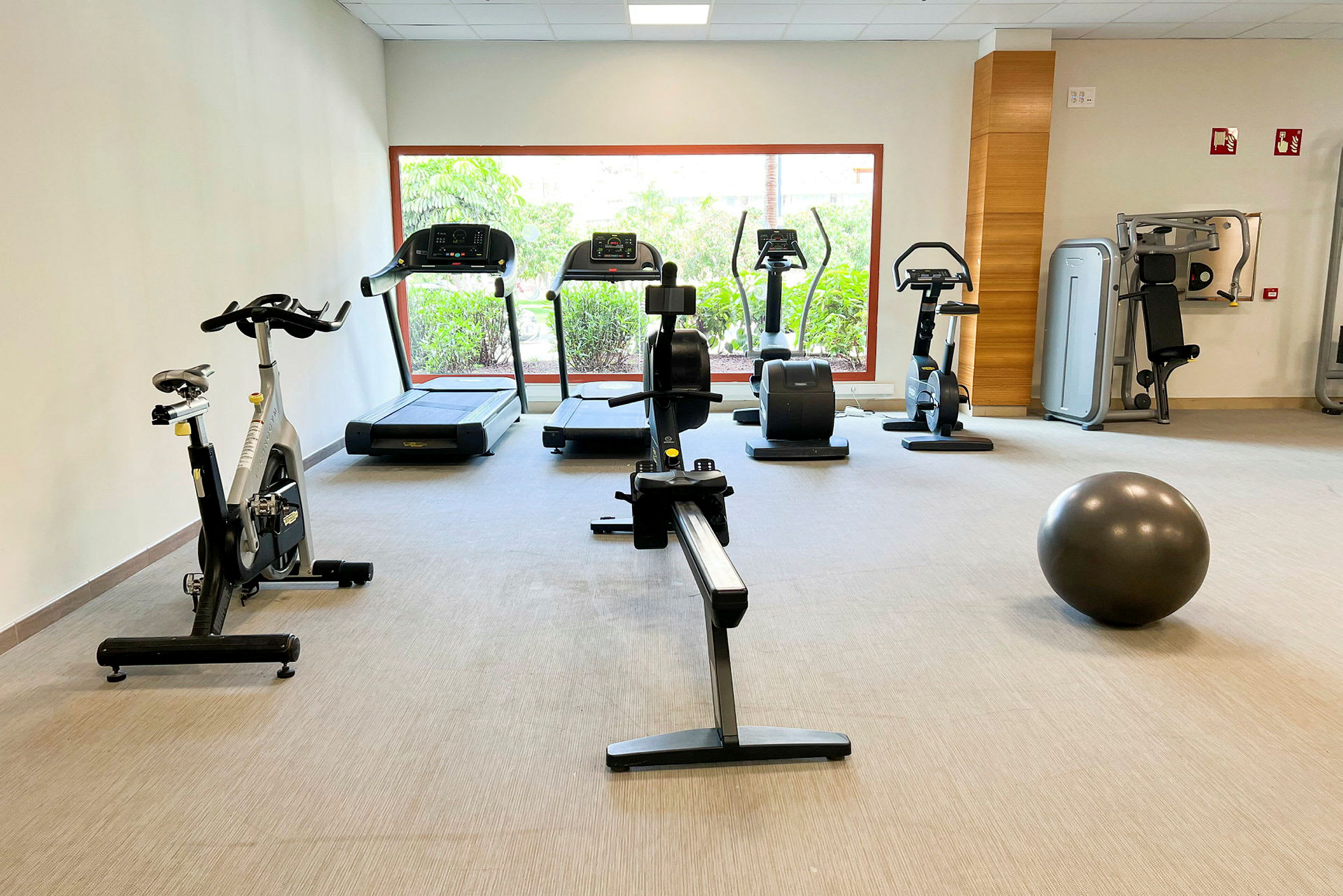 Fitnessrum med træningsmaskiner og udstyr. (AI-genereret tekst)