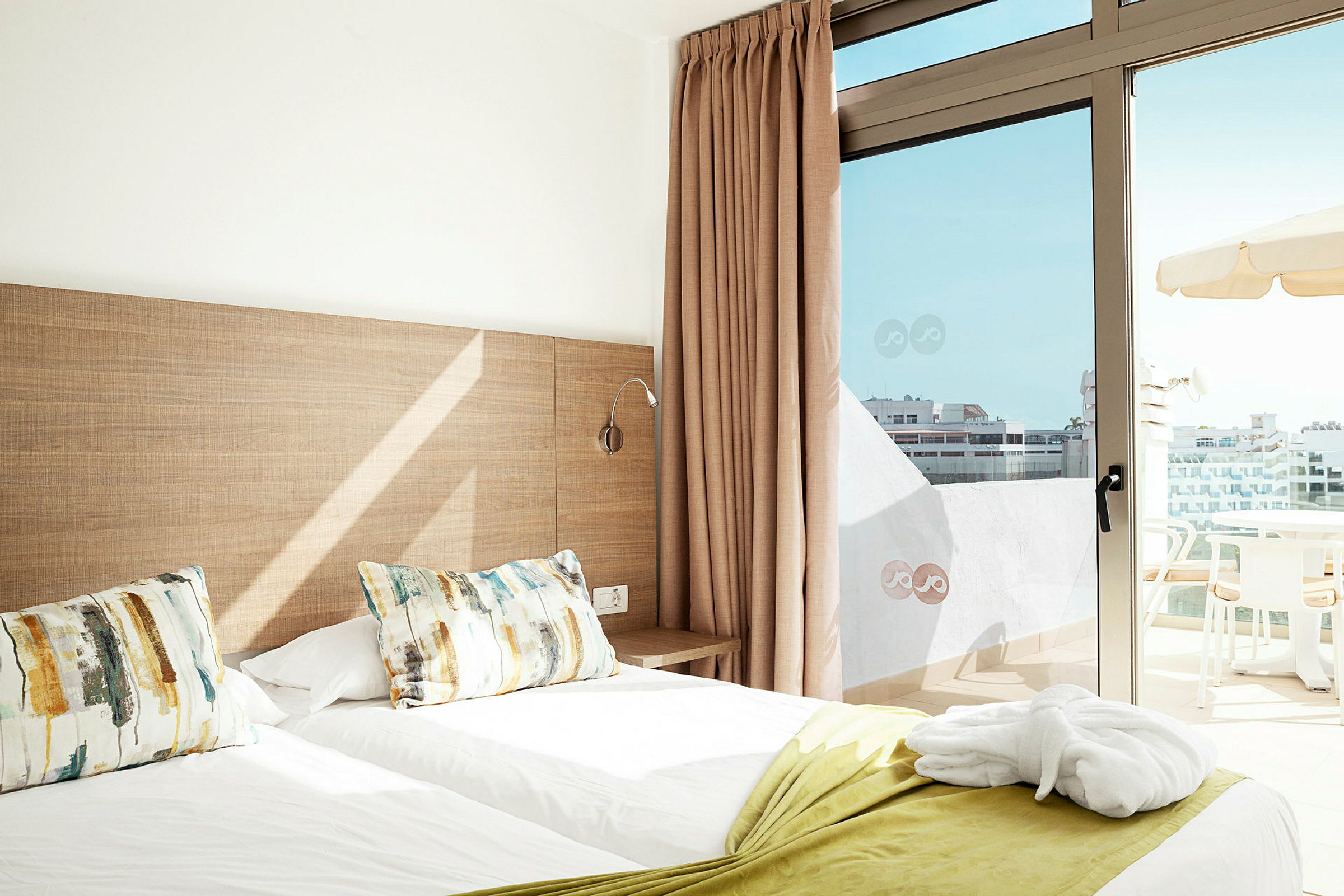 Hotelværelse med to enkeltsenge og en balkon med udsigt. (AI-genereret tekst)