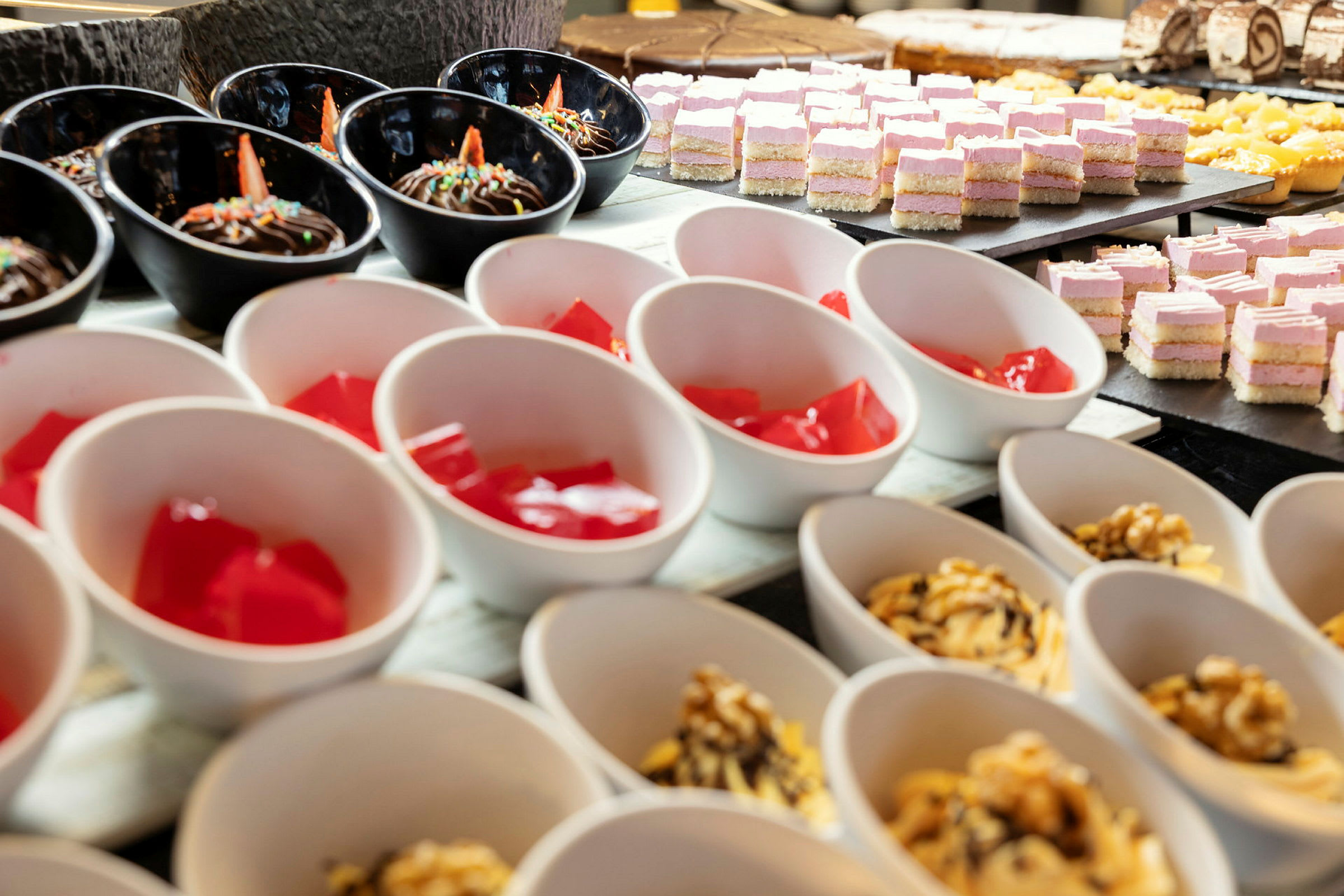 Nærbillede af desserter på et buffetbord. (AI-genereret tekst)