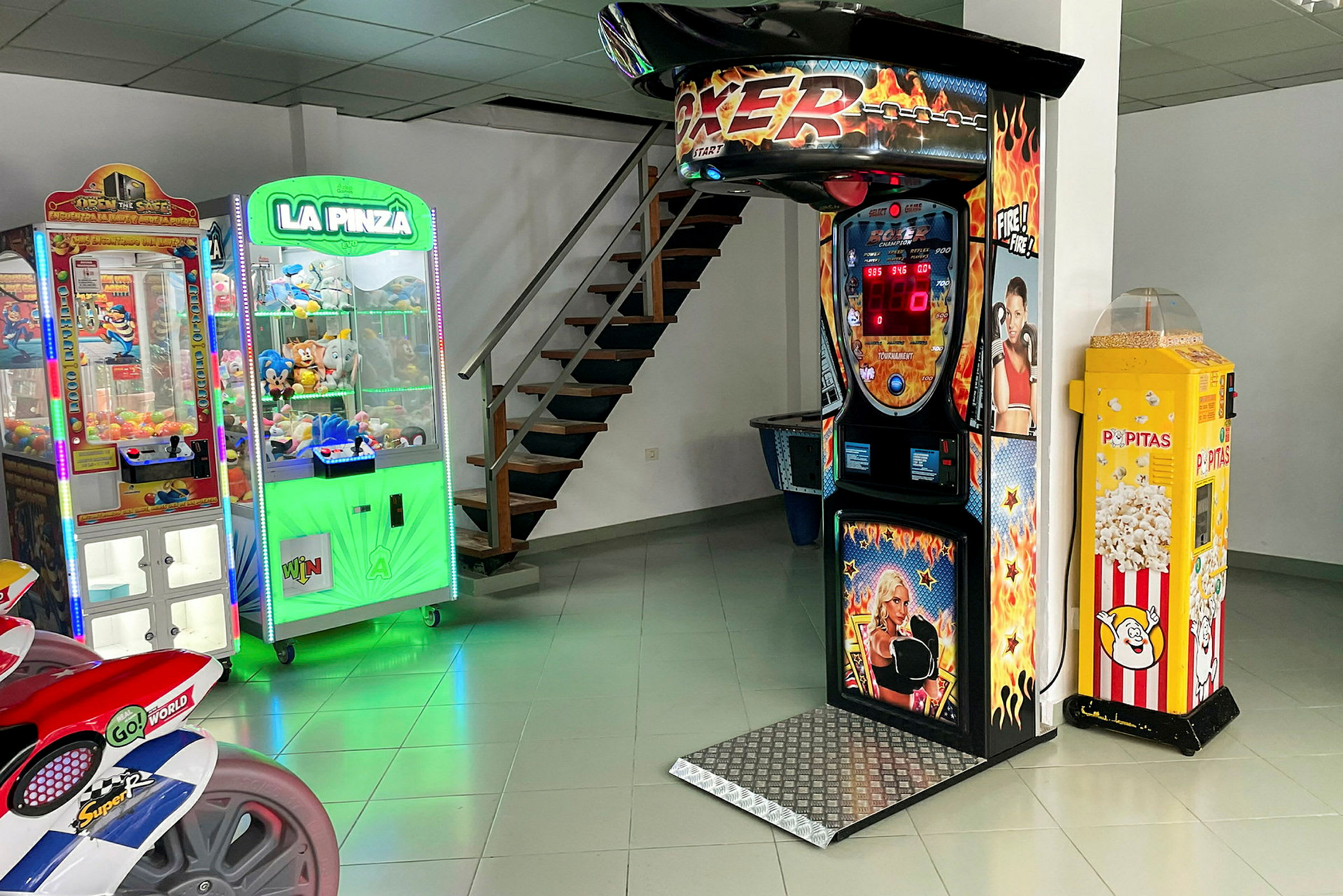 Et rum med forskellige spillemaskiner, herunder en boksemaskine, klo-spil og en popcornautomat. (AI-genereret tekst)