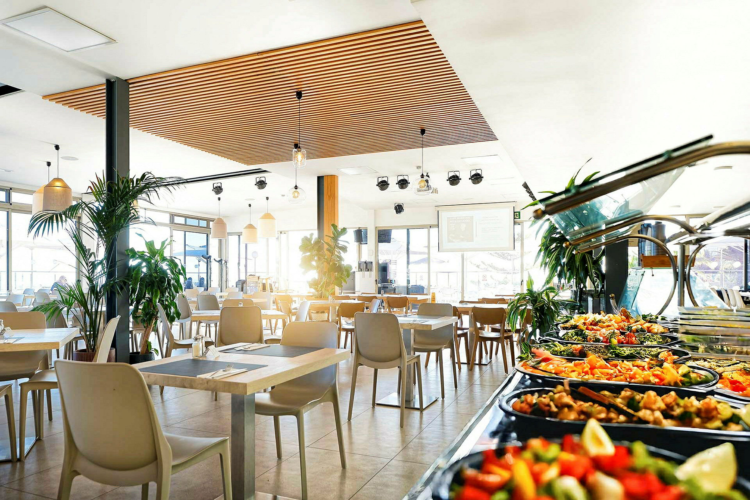 Restaurant med moderne møbler og buffetbord med salater og tilbehør. (AI-genereret tekst)