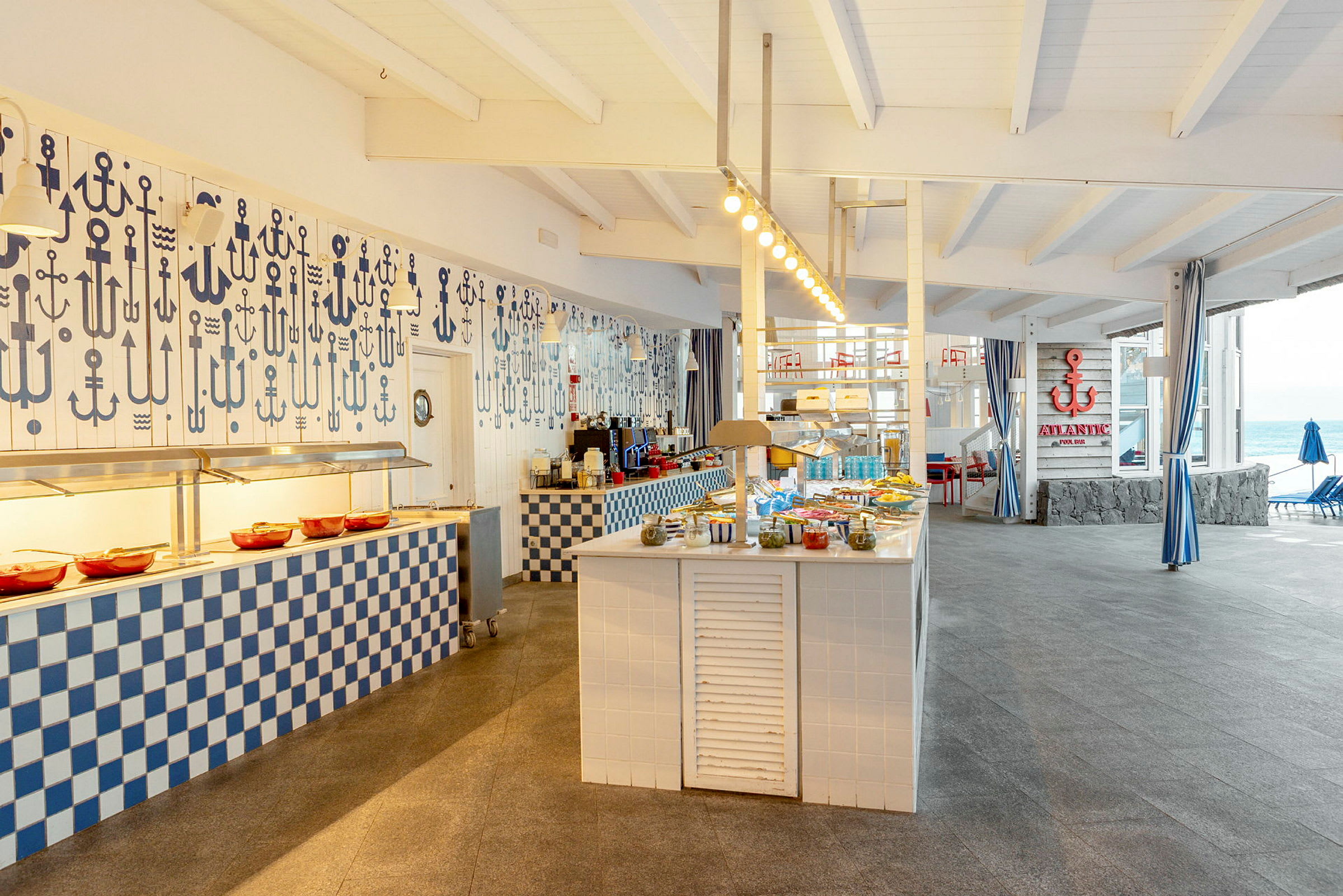 Billede af en buffetrestaurant med maritimt tema, med opdækkede borde og dekorationer. (AI-genereret tekst)