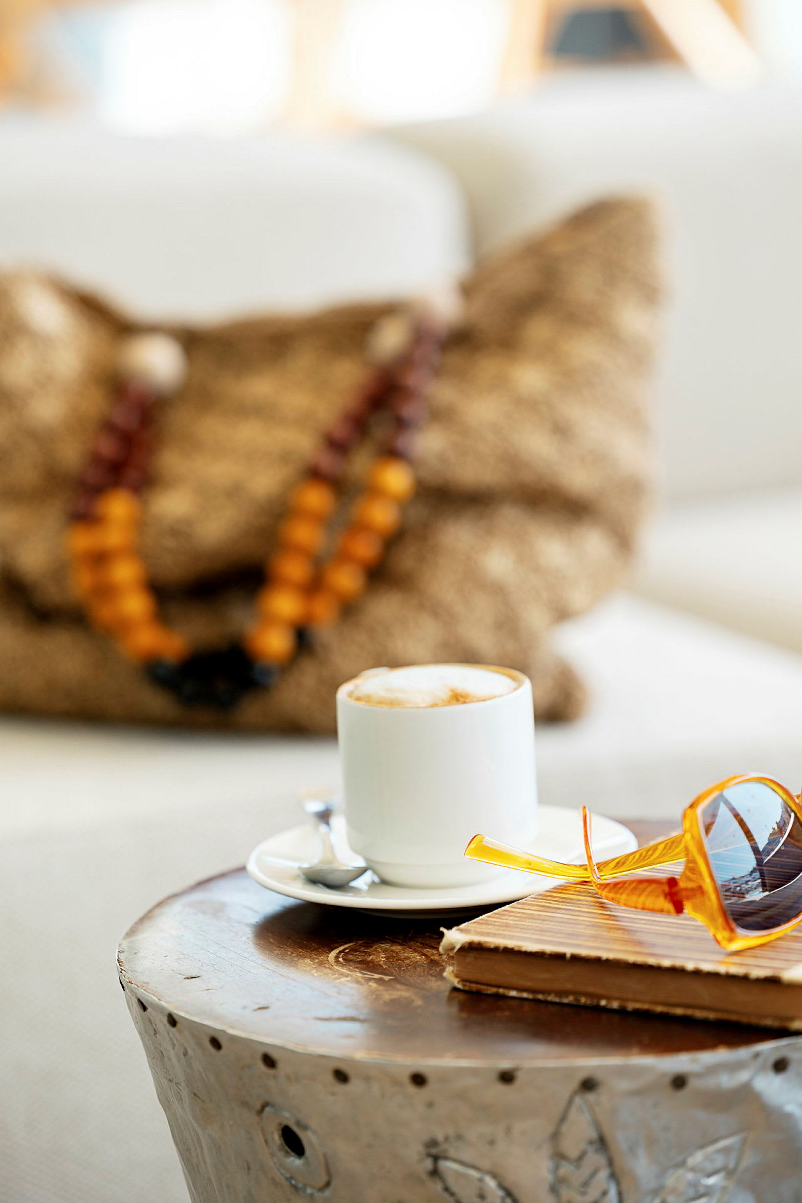 En kop kaffe på et bord sammen med briller og en notesbog. (AI-genereret tekst)