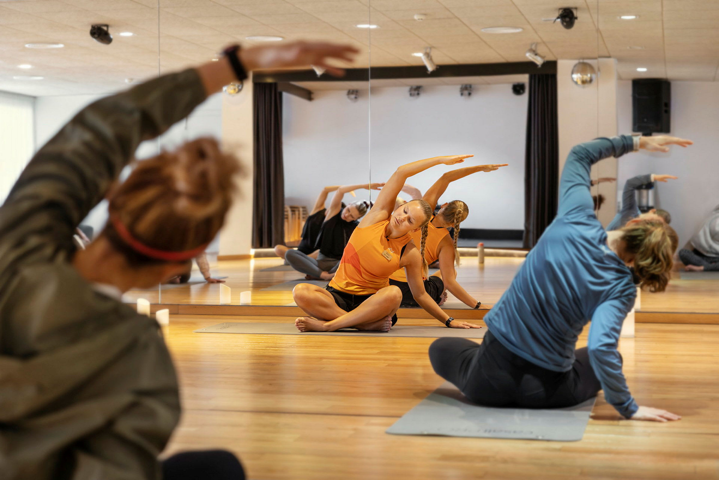 En gruppe mennesker træner yoga i en spejlsal. (AI-genereret tekst)