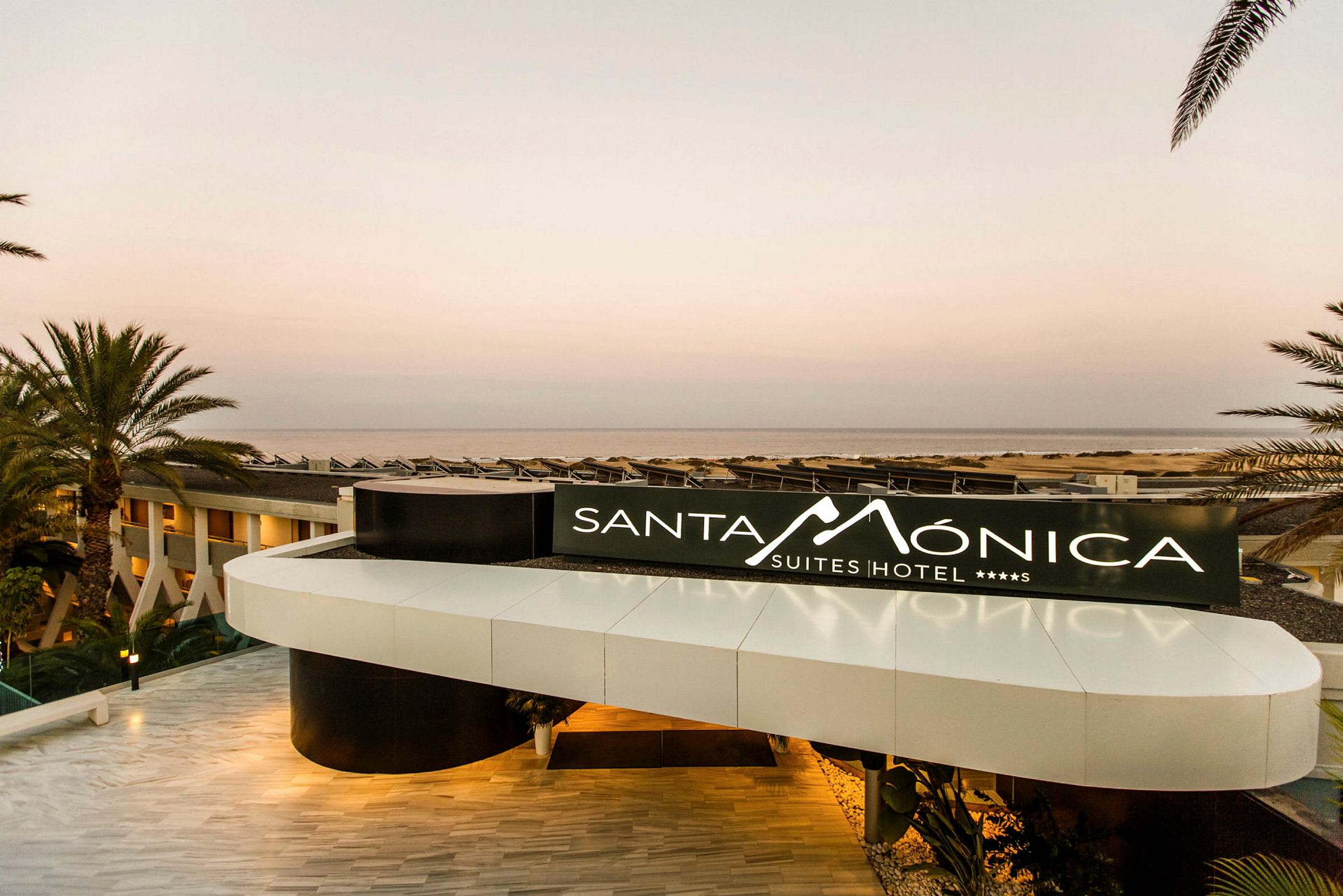 Indgang med skilt til Santa Monica Suites Hotel. (AI-genereret tekst)