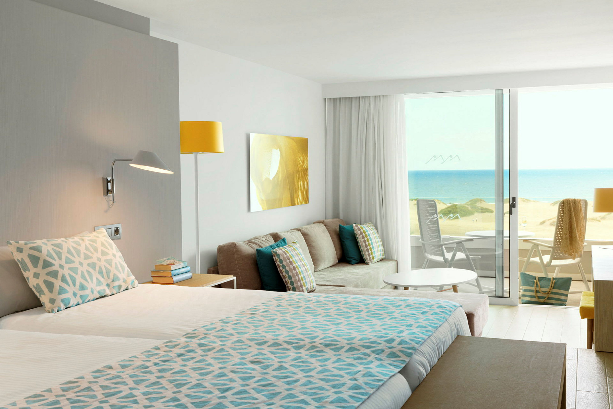 Hotelværelse med udsigt over en sandstrand og havet. (AI-genereret tekst)