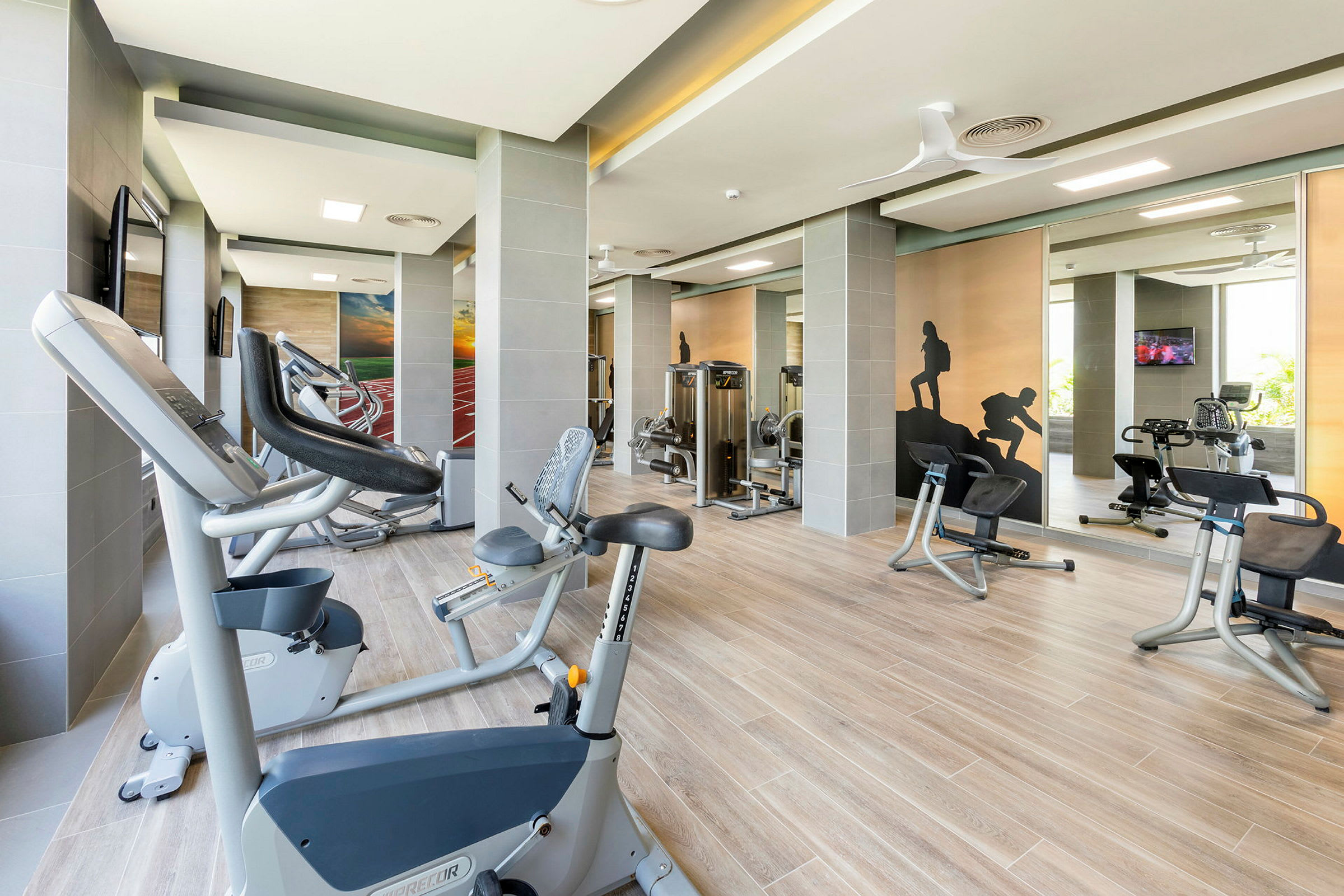 Et fitnesscenter med moderne træningsmaskiner og dekorerede vægge. (AI-genereret tekst)