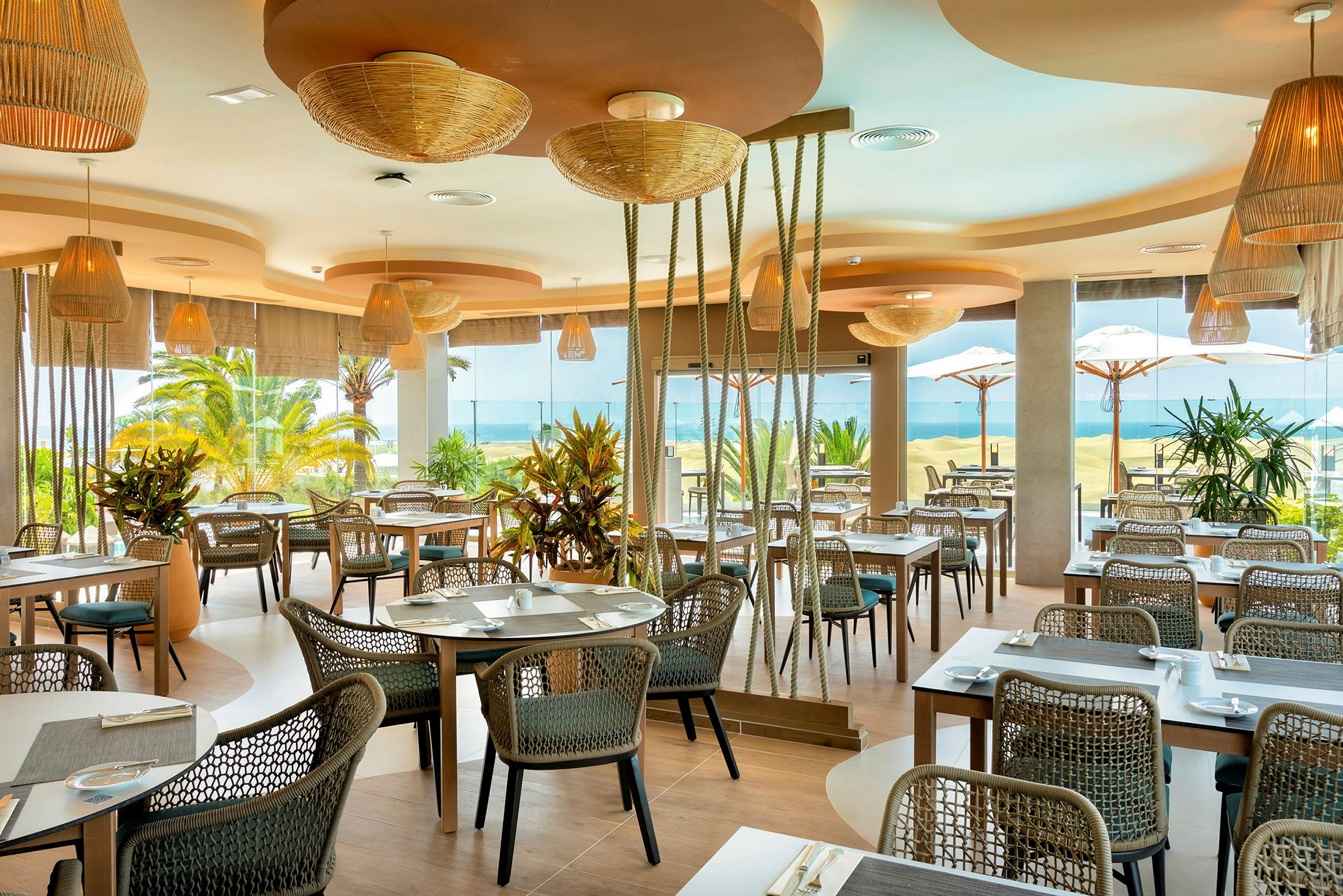 Restaurant med moderne møbler og store vinduer vendt mod stranden. (AI-genereret tekst)