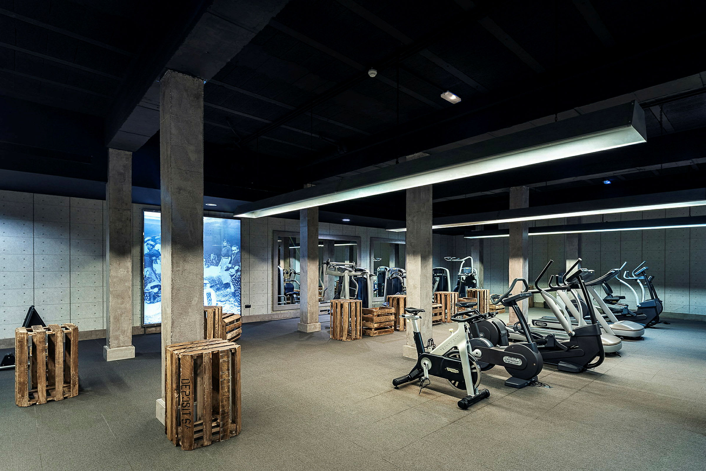 Et fitnesscenter med træningsudstyr og trækasser som dekoration. (AI-genereret tekst)