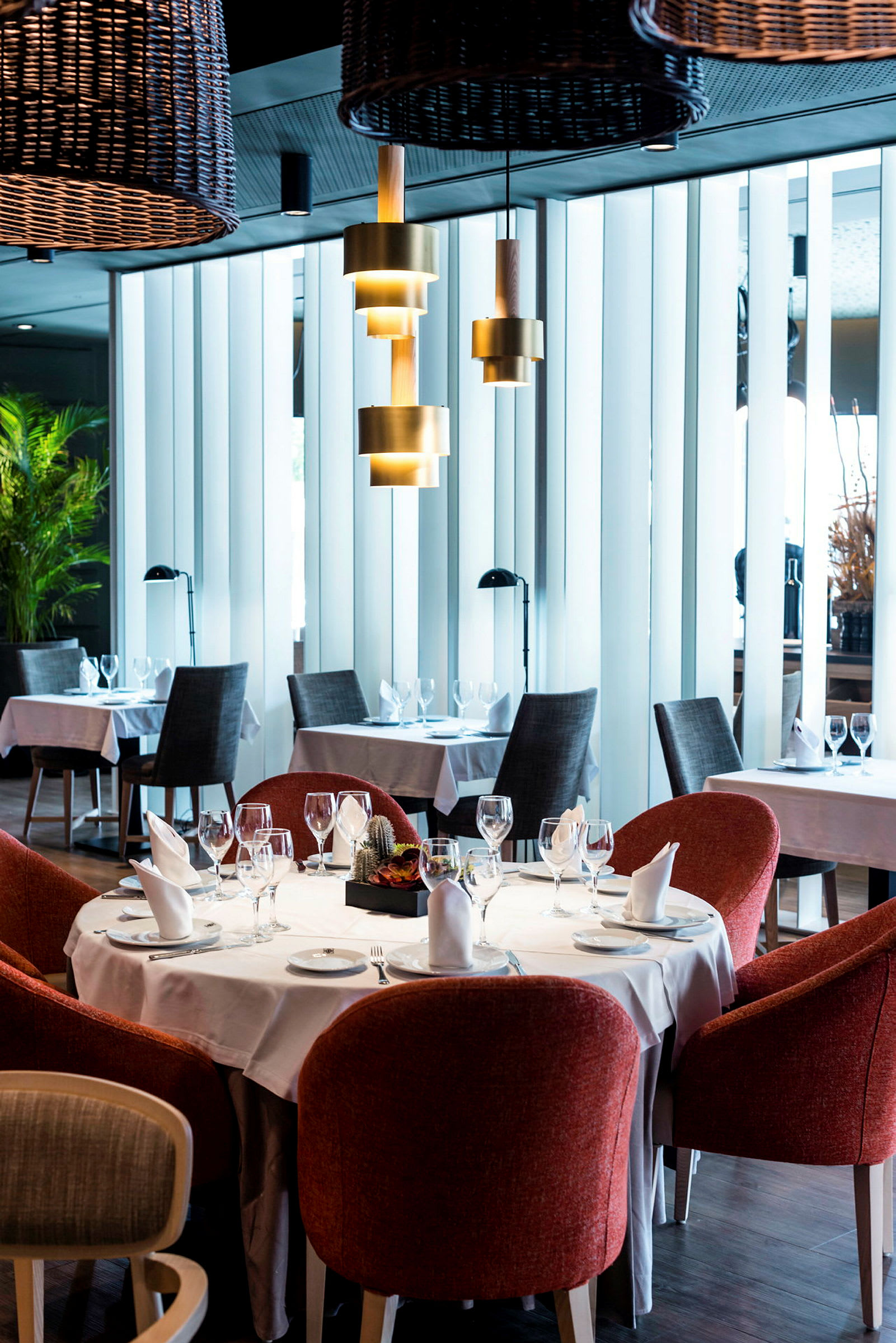 En restaurant med dækkede borde og røde stole. (AI-genereret tekst)