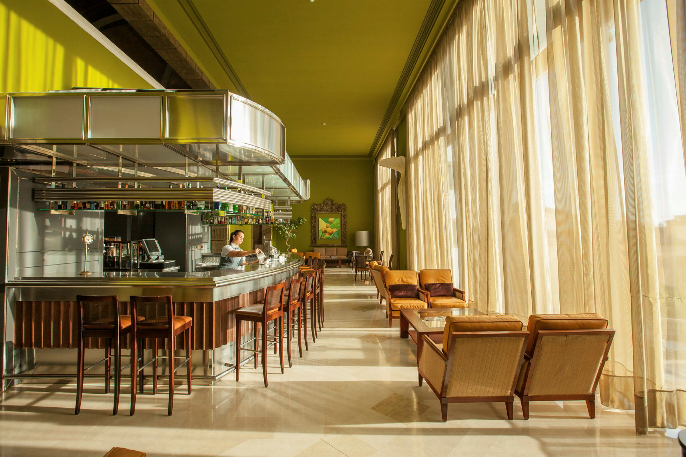 Elegant bar med moderne stole og borde ved store vinduer. (AI-genereret tekst)