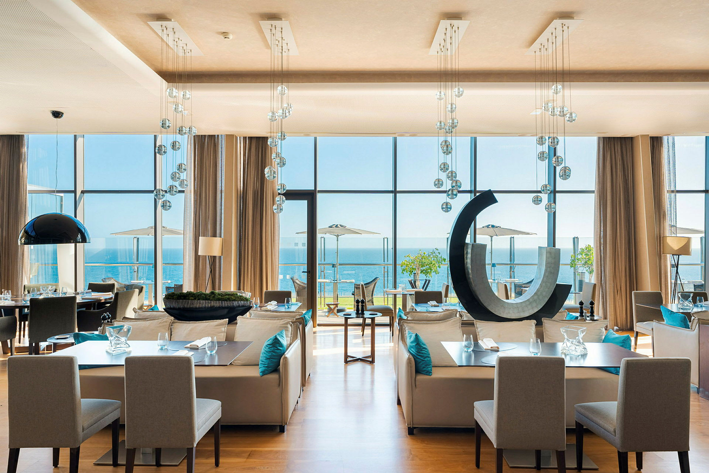 Moderne restaurant med store vinduer mod havet. (AI-genereret tekst)