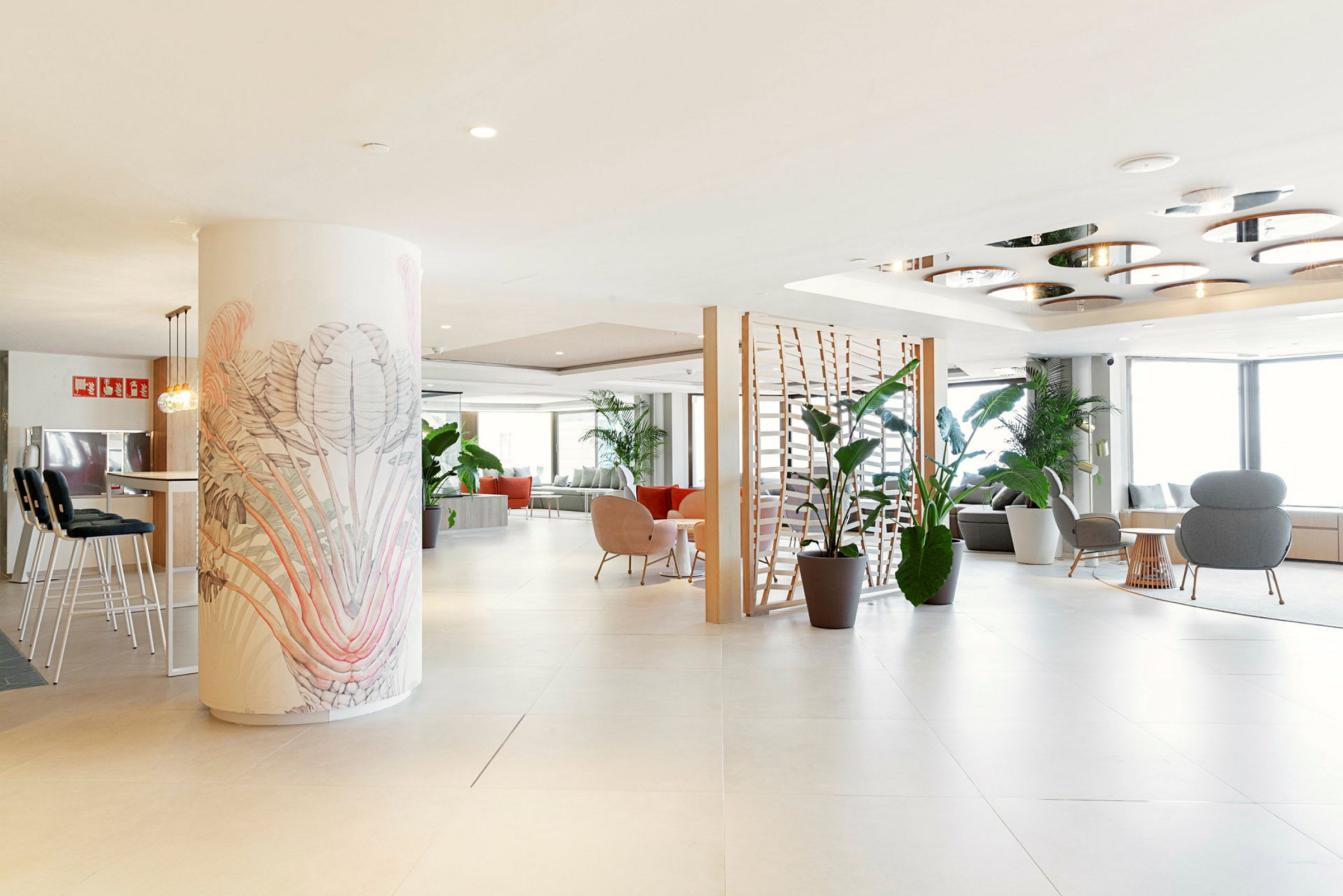 En rummelig og lyst indrettet hotellobby med flere siddearrangementer og grønne planter. (AI-genereret tekst)