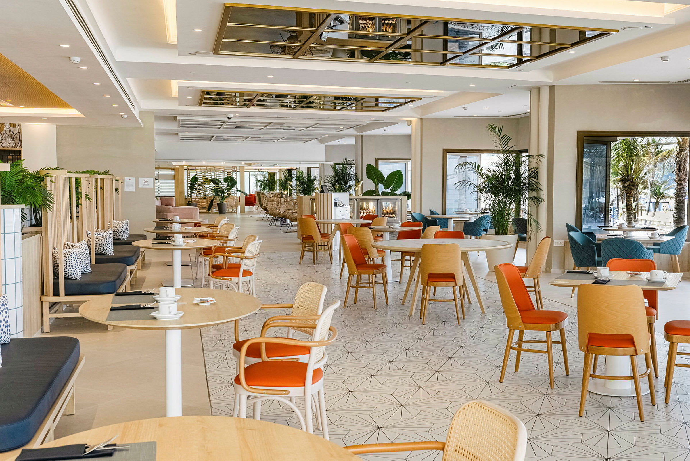 En lys og moderne café med træborde og stole samt plantepynt. (AI-genereret tekst)