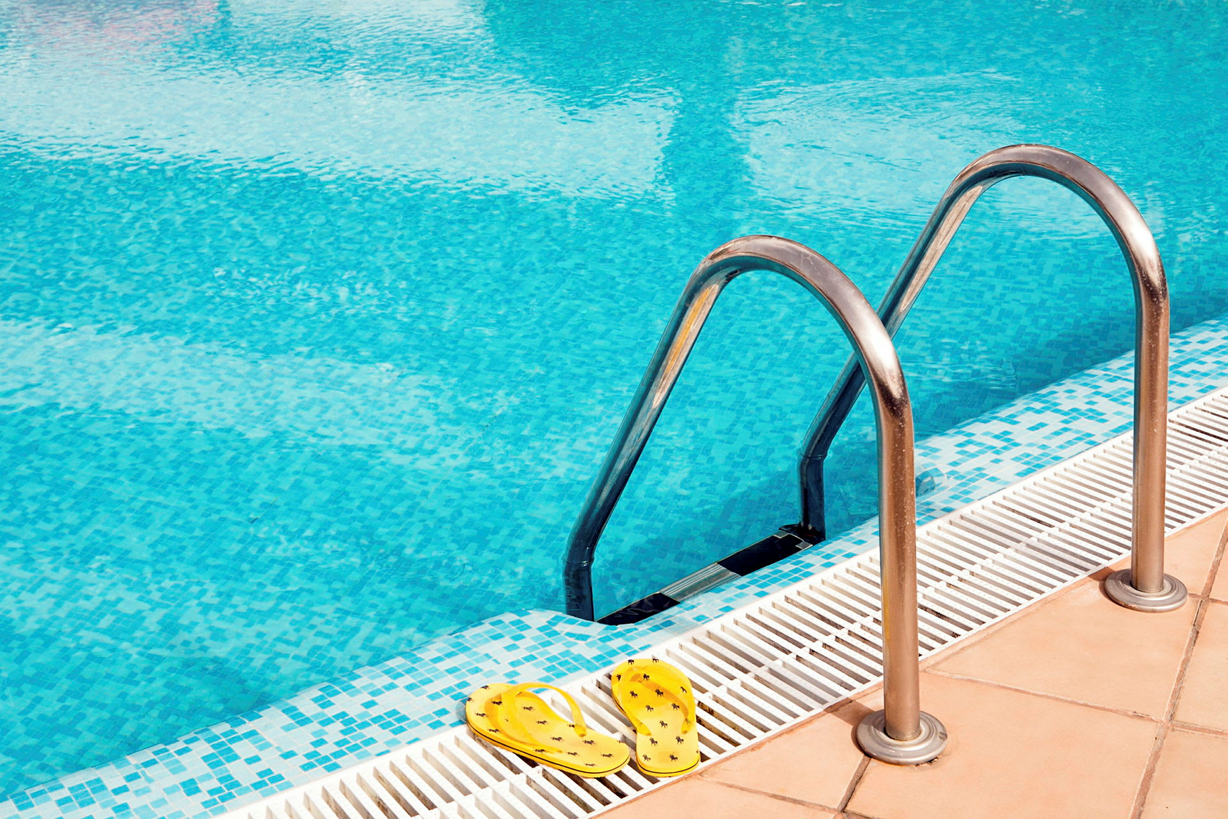 Billede af en pool med metalstige og gule sandaler ved kanten. (AI-genereret tekst)