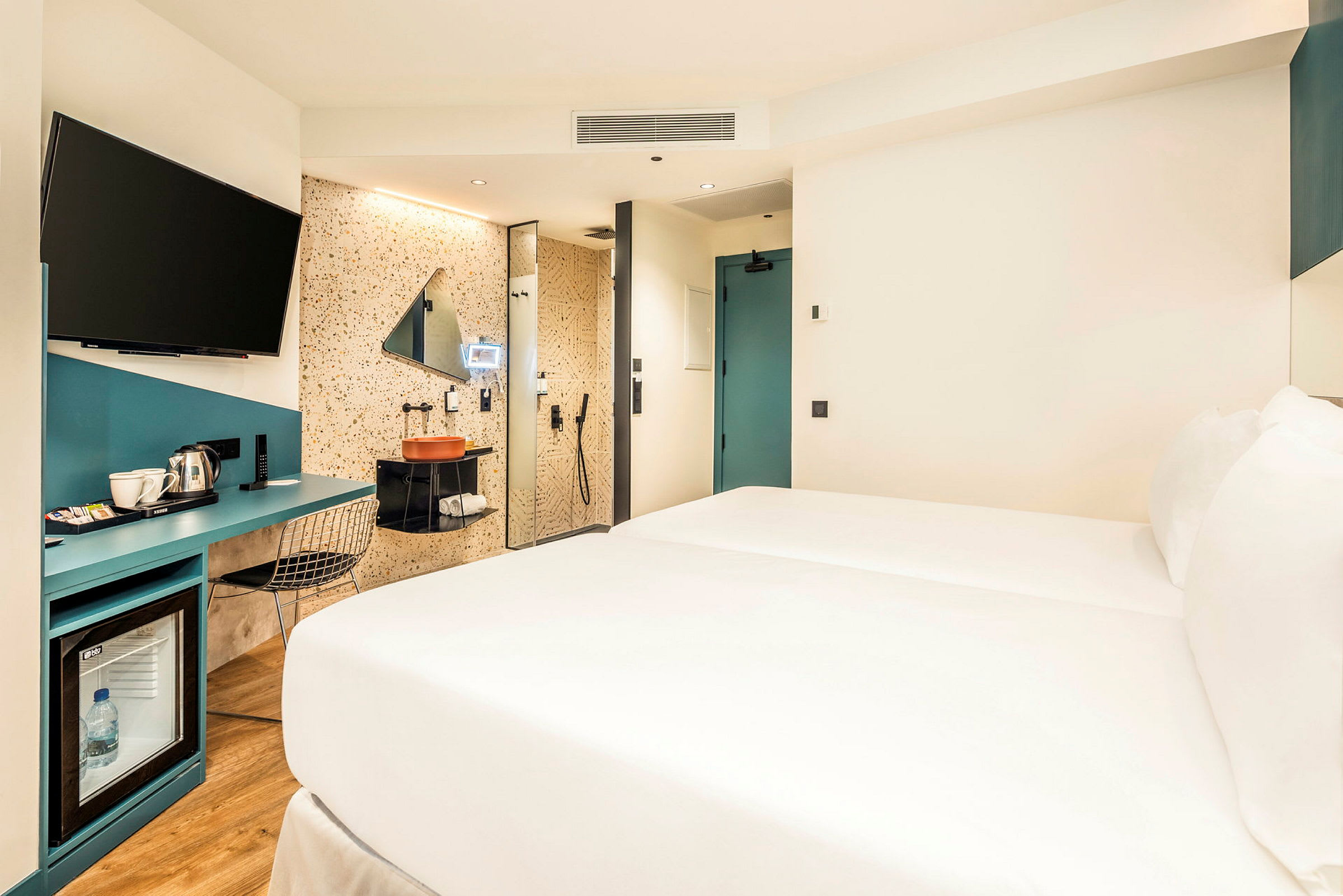 Hotelværelse med seng, skrivebord og badeområde. (AI-genereret tekst)