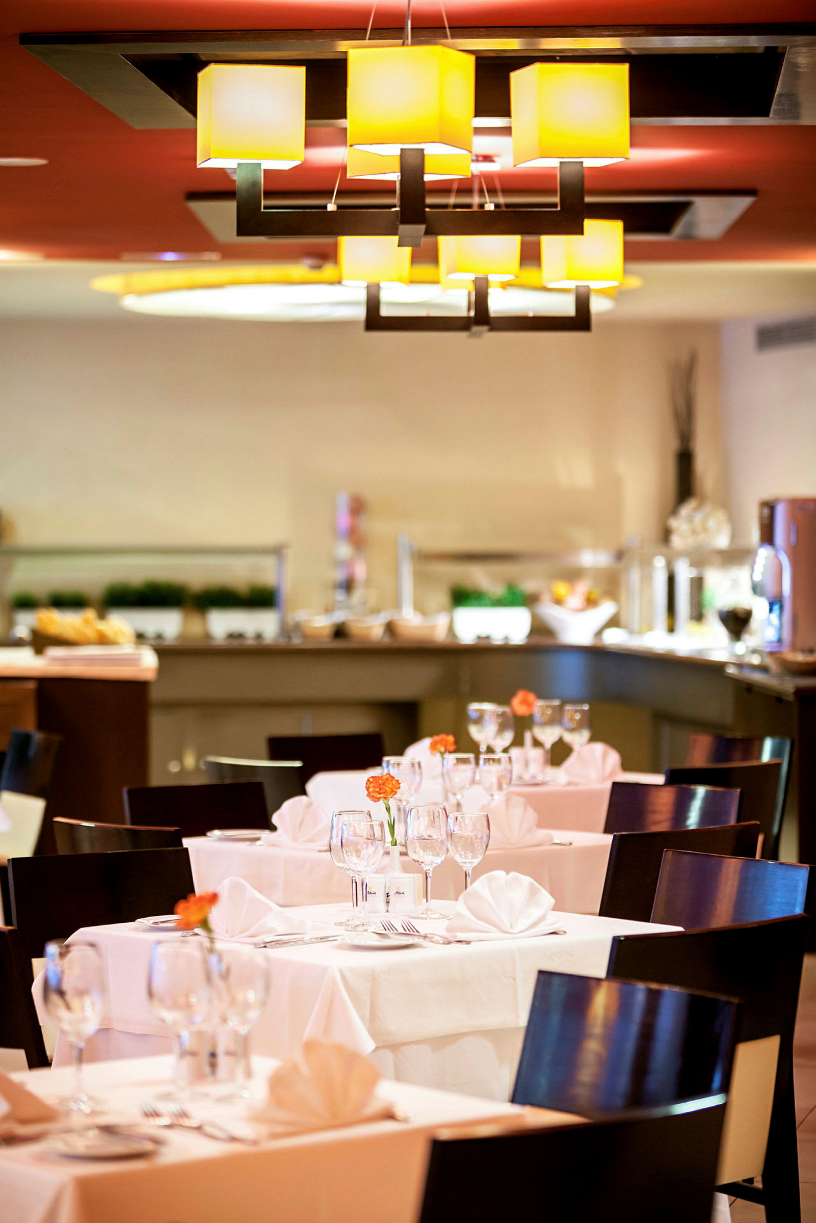 Restaurant med dækkede borde, stole og lys indretning. (AI-genereret tekst)