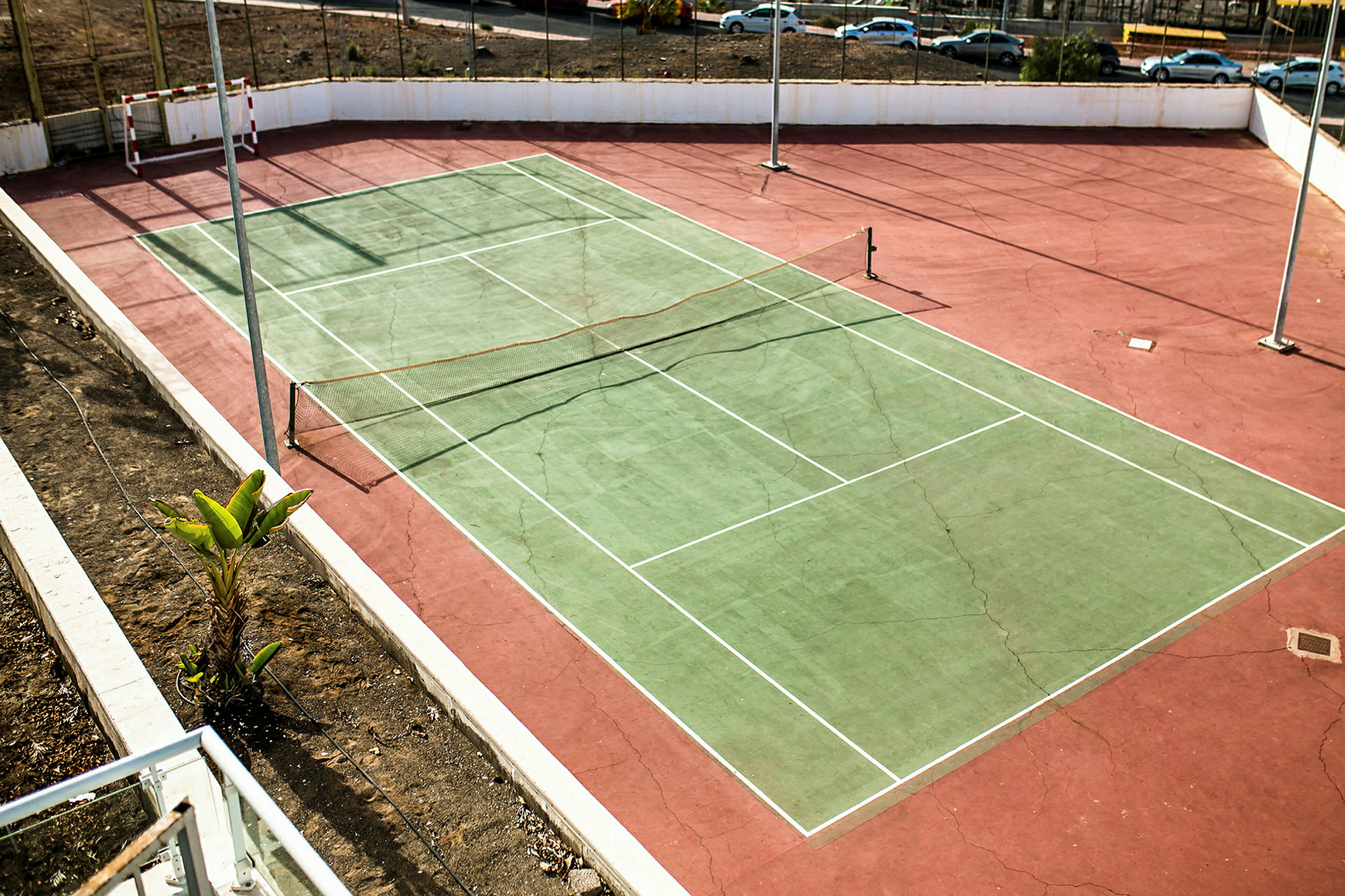 En åben tennisbane med net. (AI-genereret tekst)