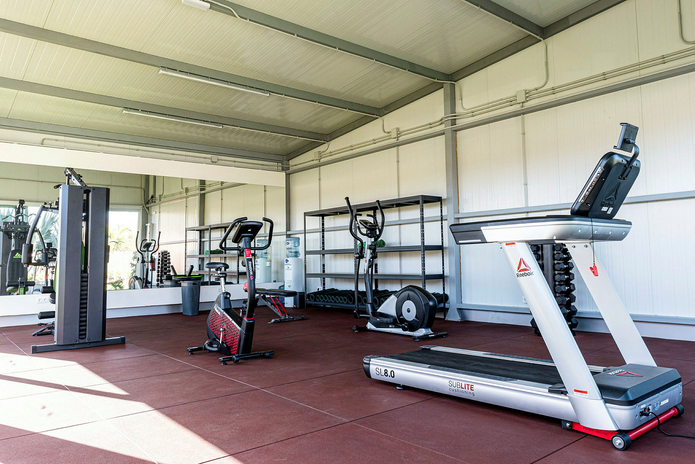 Træningsområde med fitnessmaskiner som løbebånd og motionscykler. (AI-genereret tekst)