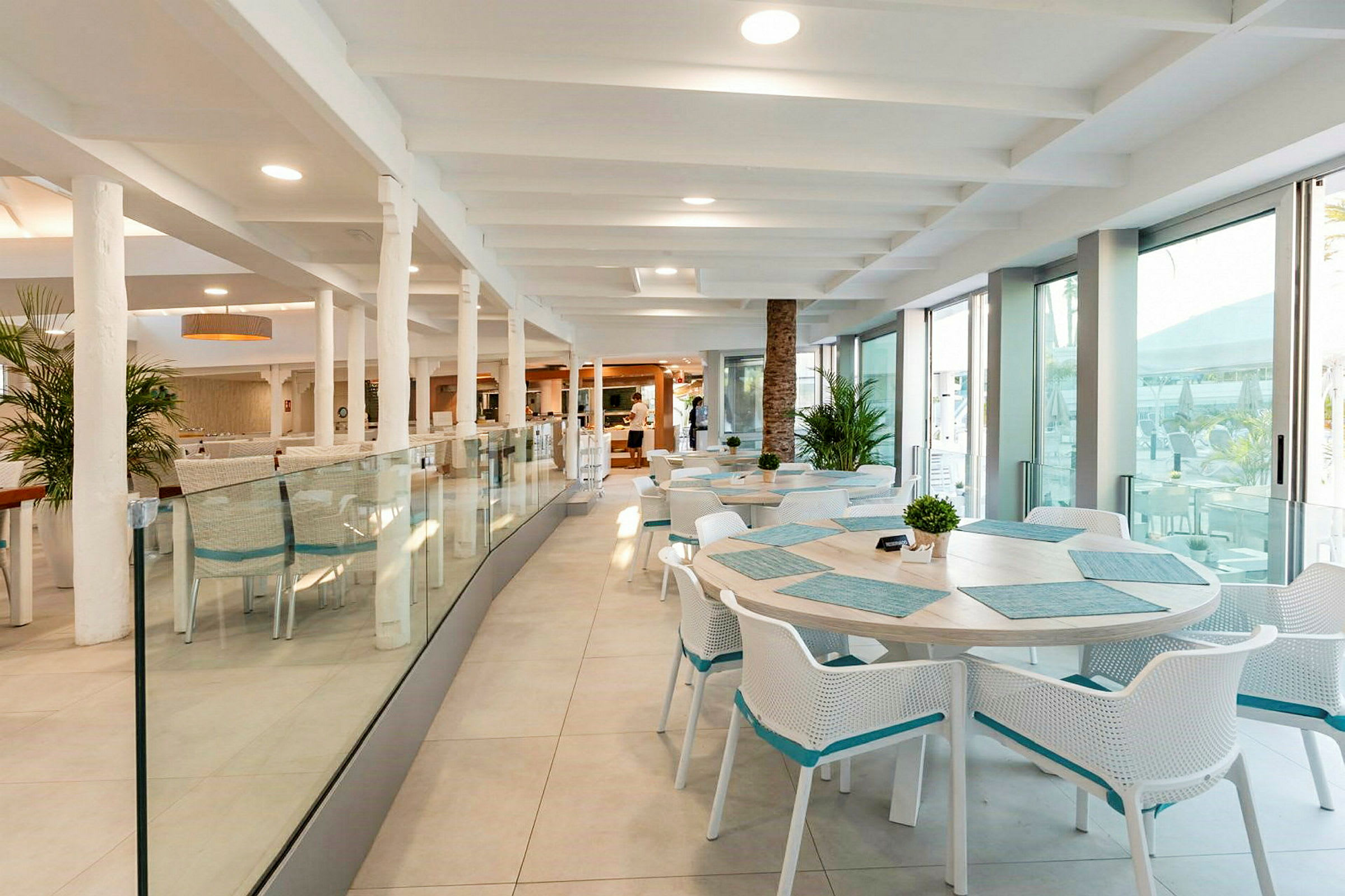Interiør af en lys restaurant med borde og stole. (AI-genereret tekst)