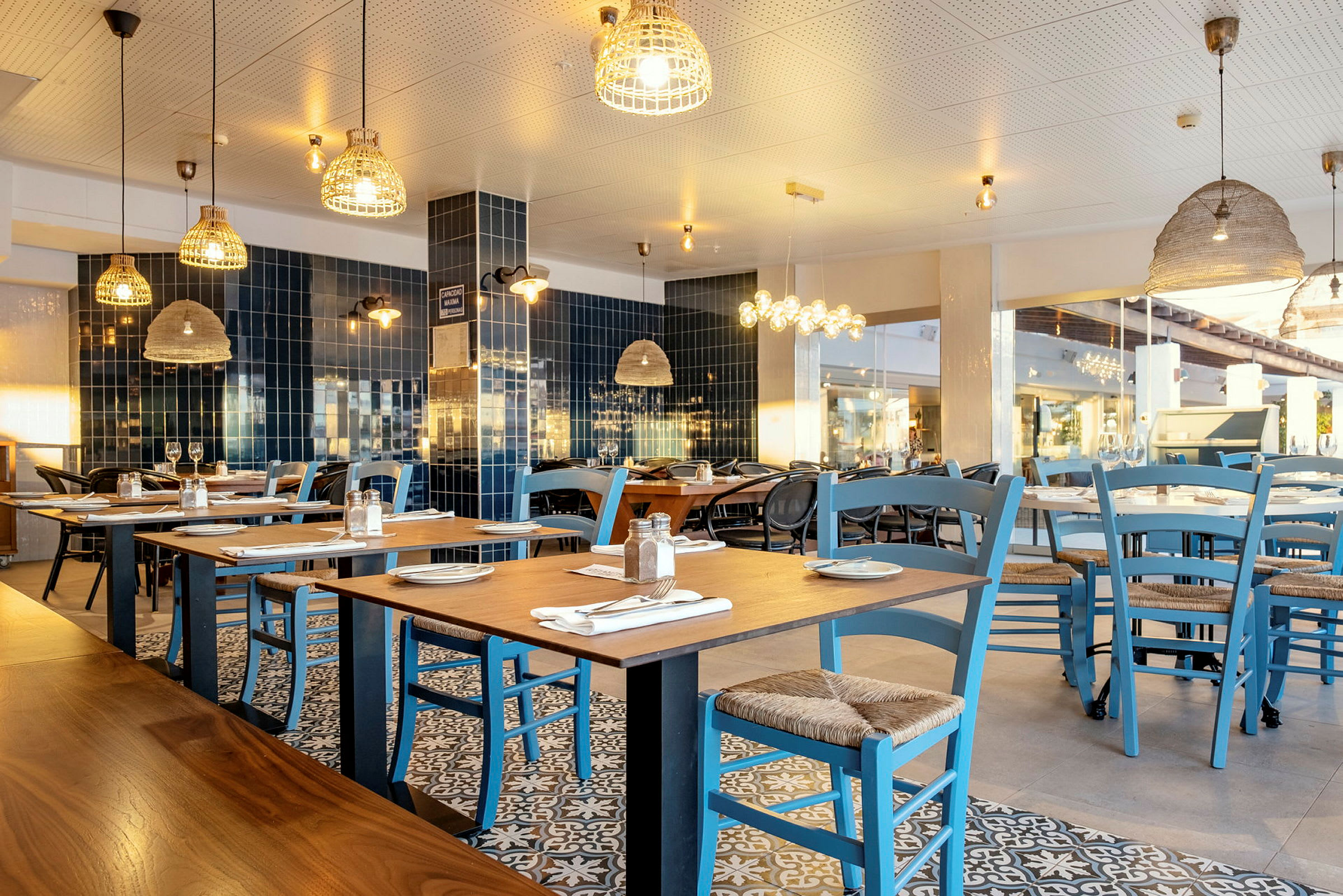 En restaurant med borde og blå stole. (AI-genereret tekst)