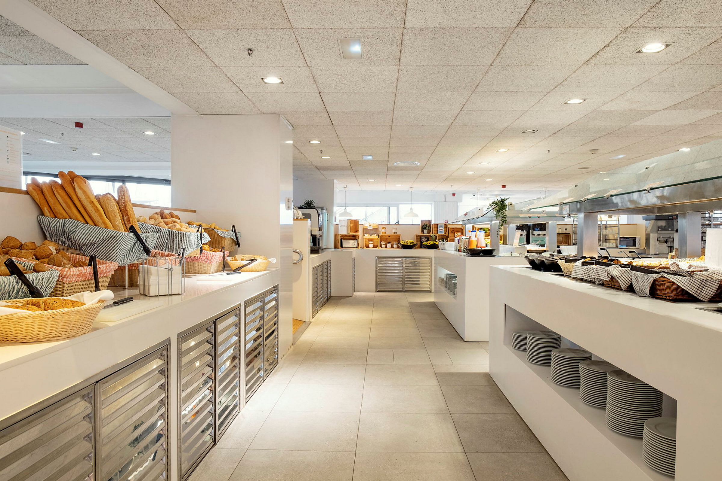 Morgenmadsbuffet på et hotel med friskbagt brød, tallerkener og serveringsstationer. (AI-genereret tekst)