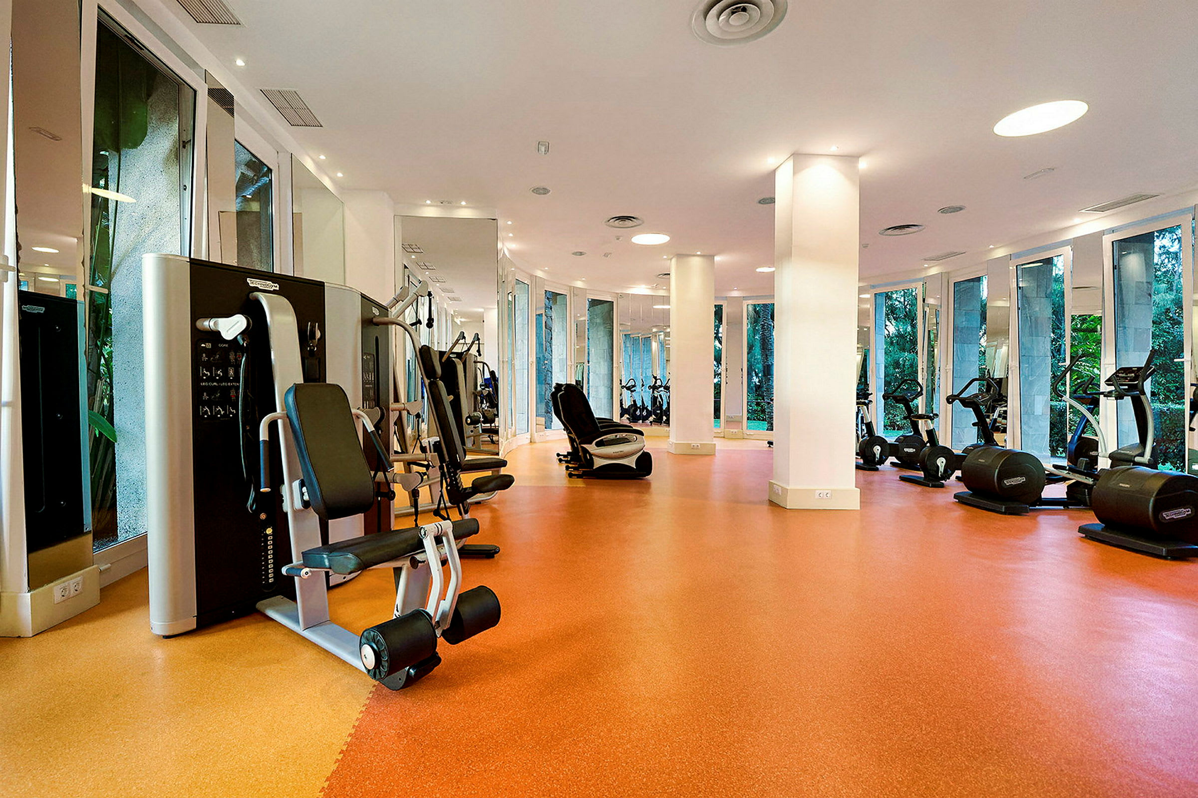 Et fitnesscenter med træningsmaskiner og afdæmpet belysning. (AI-genereret tekst)