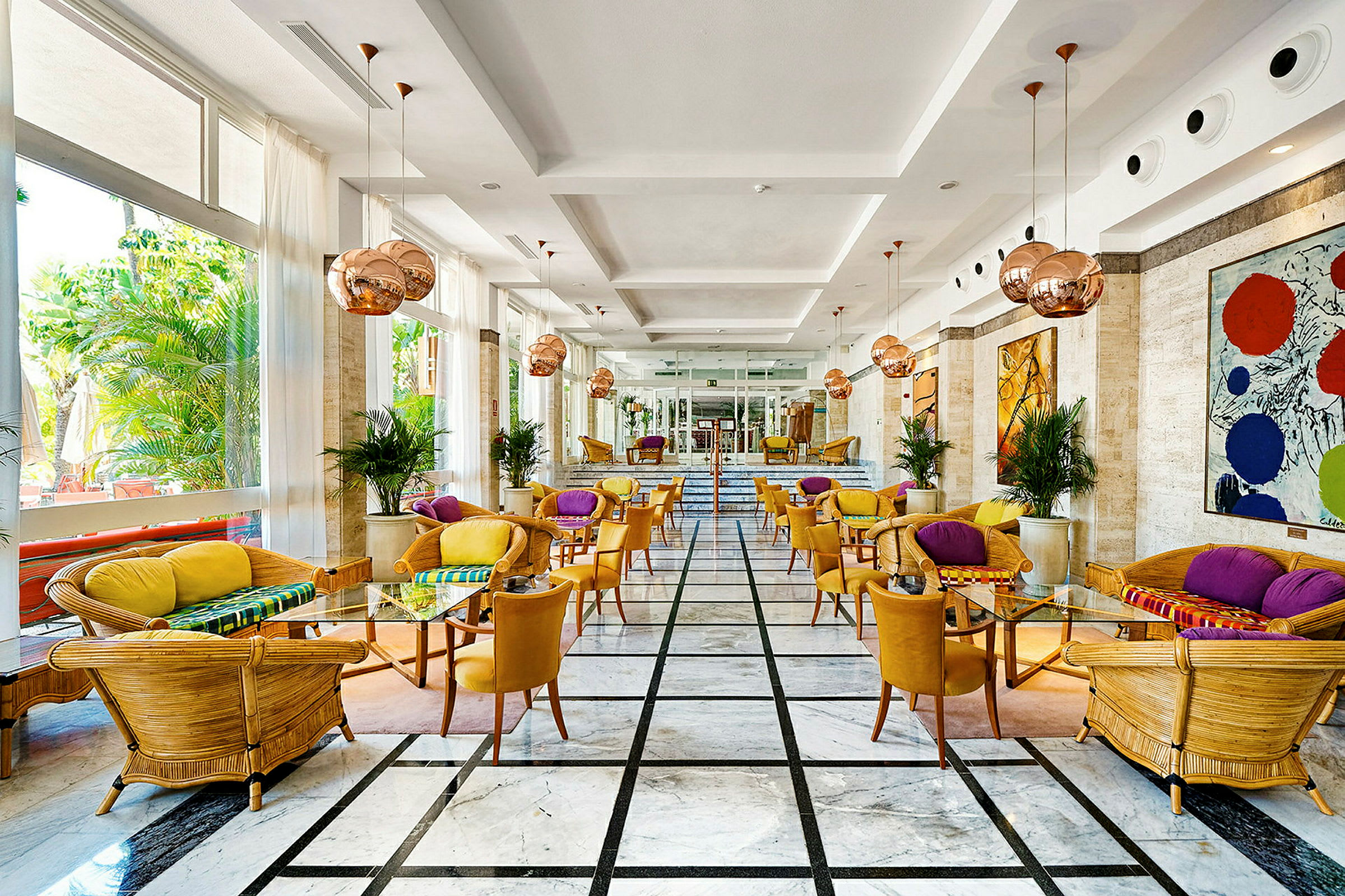 Interiør af en hotellounge med farverigt interiør og store vinduer. (AI-genereret tekst)