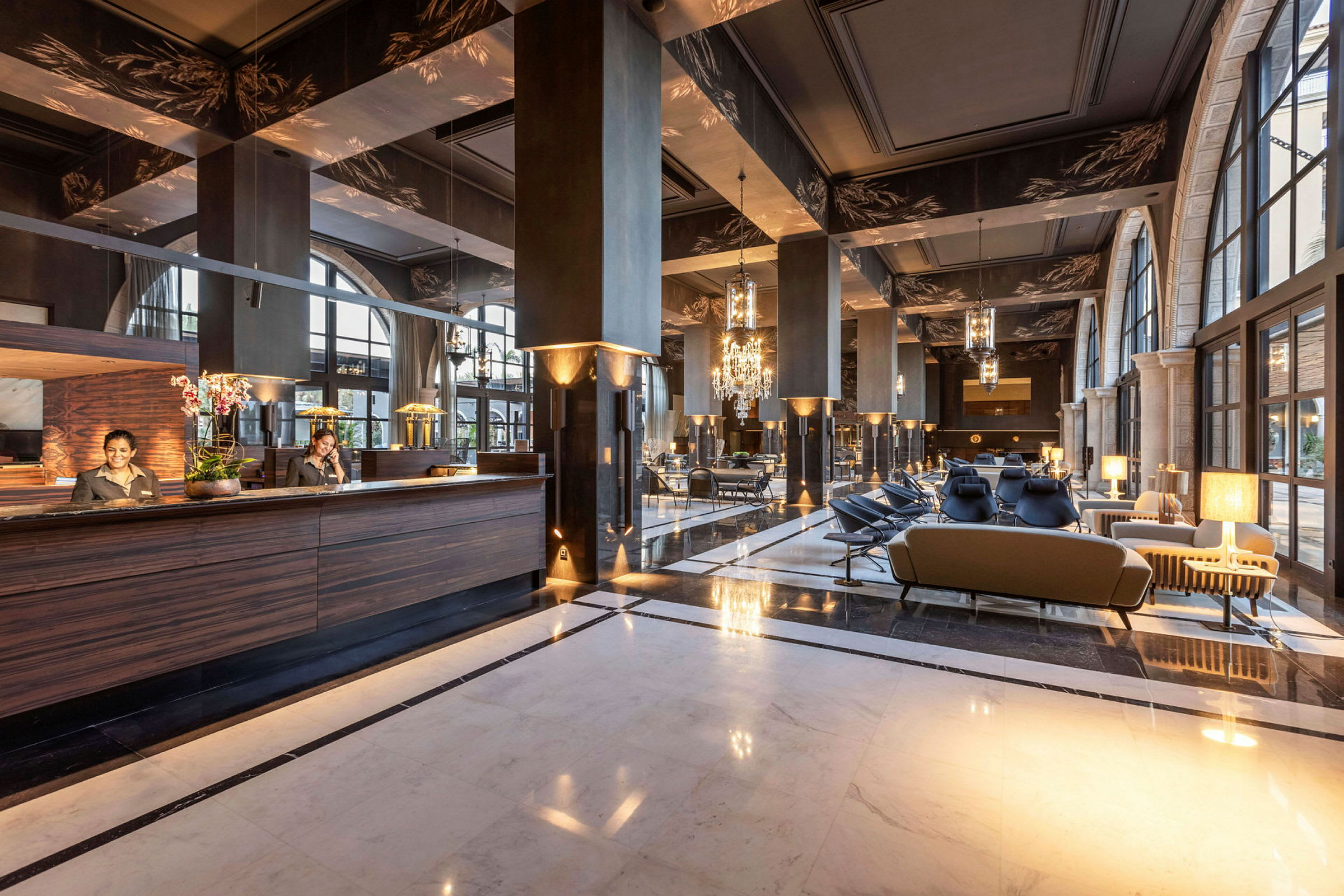 Et hotellobbyområde med elegant indretning, herunder sofaer og en receptionsdisk. (AI-genereret tekst)