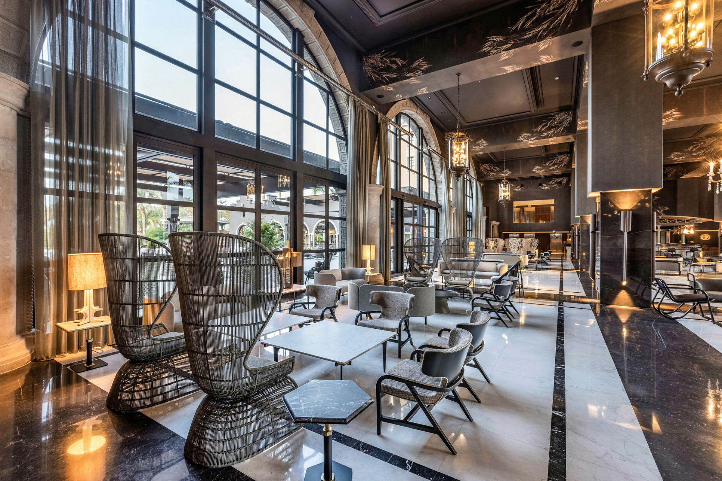 En elegant hotellobby med store vinduer, komfortable siddepladser og moderne indretning. (AI-genereret tekst)