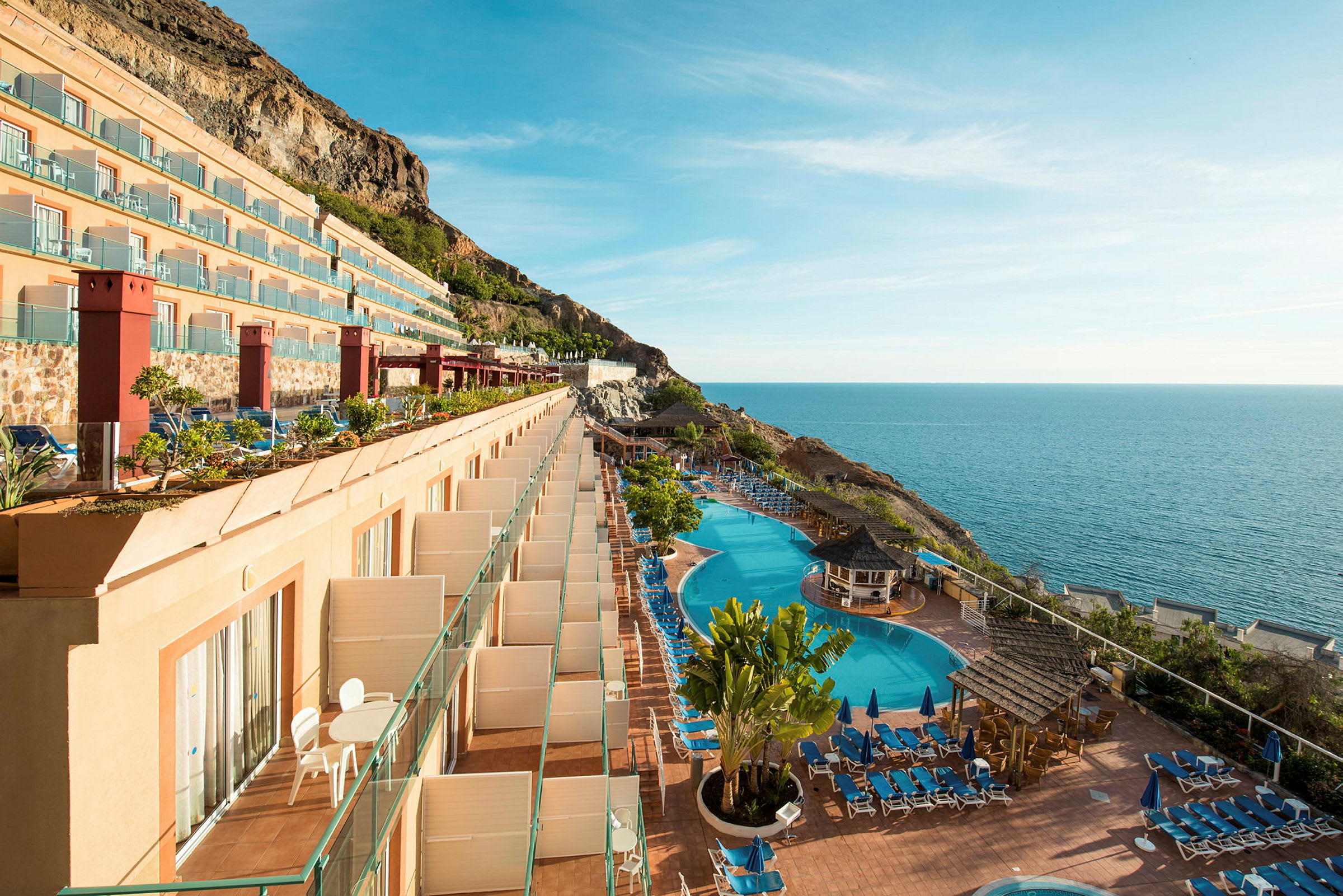 Et hotel med altaner, swimmingpools og havudsigt. (AI-genereret tekst)