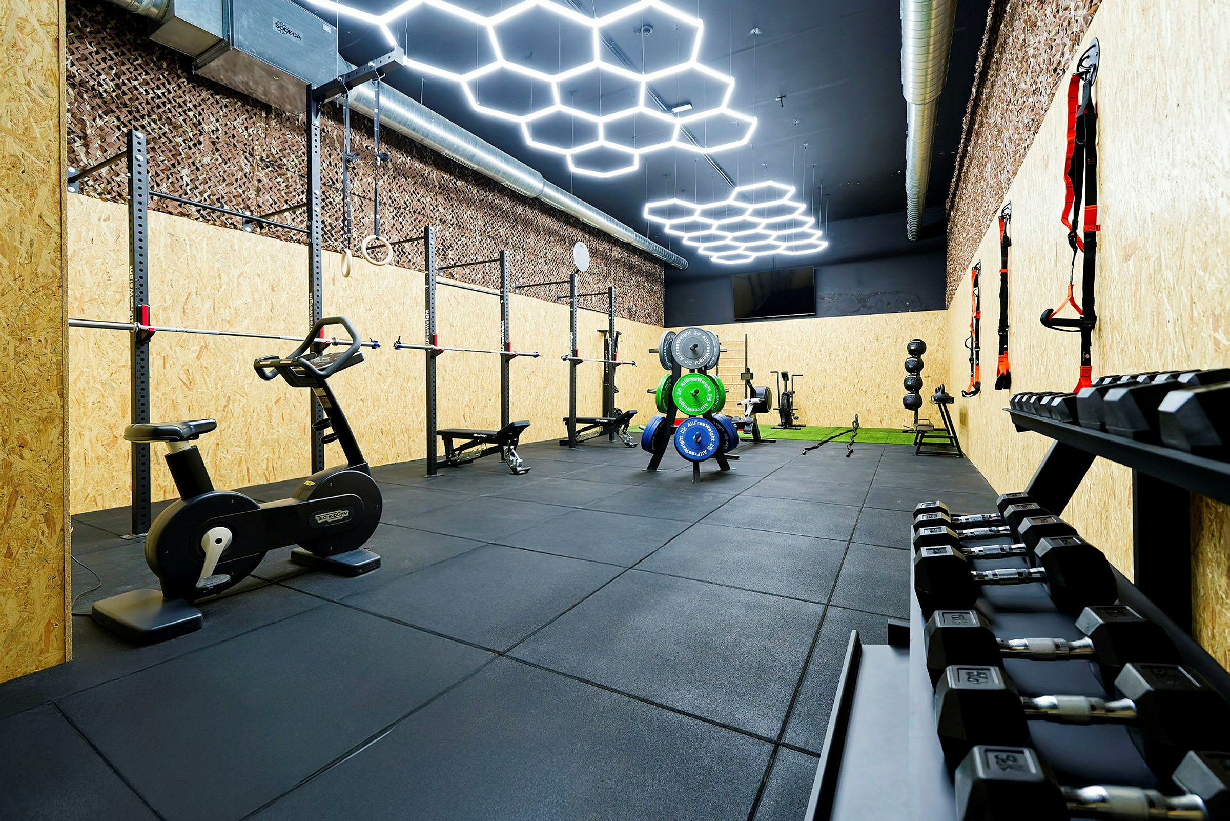 Billede af et fitnesscenter med forskellige træningsredskaber såsom vægte, motionscykler og træningsstativer. (AI-genereret tekst)
