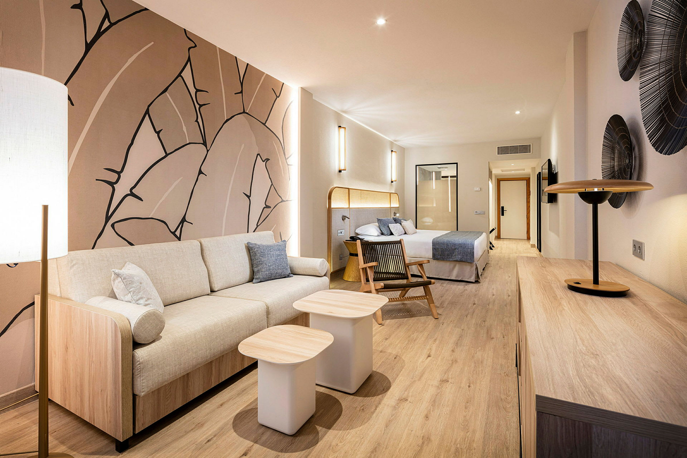 Moderne hotelsuite med siddeområde, seng og dekorativ kunst på væggen. (AI-genereret tekst)